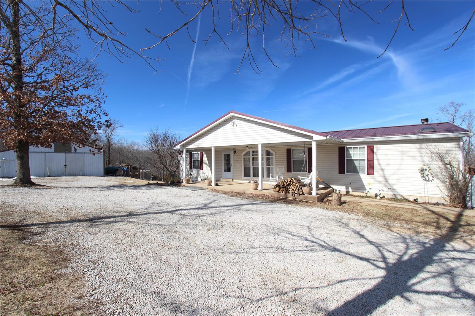 Looking for a home with acreage? This is it! Secluded yet not very far from the town of Desoto, this 3 bedroom 3 bath hunting and fishing paradise property on 28 Acres has a lot of features;  metal roof, luxury vinyl floor through most of the main level, a kitchen with granite countertops, center island, lots of cabinets , stainless steel appliances, main floor laundry, master bedroom suite with double sinks and walk-in closet, main floor living room and family rooms, a walkout finished basement with an additional bathroom and possible 4th bedroom, along with a large rec/game area with a bar.  Outside the back of the home is a large covered deck, a covered patio underneath it and above ground pool, and a large cleared area overlooking the valley behind the home. There is also detached building for additional parking that has 4 horse stalls and a tack room! Lake and Big River Access Too!