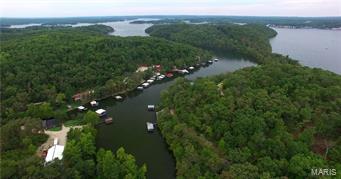 Approx. 670 wooded acres, already perimeter fenced with approx. 20 miles of perfectly manicured trails, offer abundant wildlife sign and countless ideal locations to harvest your next big buck or tom.  Several large areas have been cleared and are ready for your late season food plots.  3 springs which feed creeks throughout the property & several small ponds make perfect year round water sources for all the areas wildlife. With its lake access, breathtaking views and incredible sunsets, the most Southern portion of the property is a perfect location for your new secluded home or cabin.  Build how you like, when you like, or not at all. 2400 sq ft steel building with 600 sq. ft. of living quarters is located in the center of the property, perfect for storing all of your equipment and lake necessities.  Over 2 miles of blacktop frontage with county water & electric available. With its lake front access and proximity to all the attractions at Lake of the Ozarks.