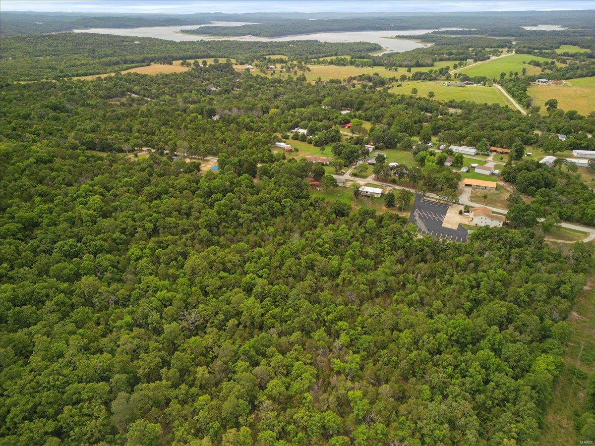 Great location for a vacation or rental property or for a permanent residence. Zoned agriculture, this property located less than 2 miles from Bull Shoals Lake and a public boat landing, is the perfect getaway investment. There is a manufactured home on the property that is livable but needs lots of work, Land has a slight roll with enough open land for a cow or horse and there is already a chicken coop in place. The garage has electric as well as there is an additional power pole and electric on the adjoining lot. The property has a private well and septic and is located beside a church with woods on 2 sides. Easy access on blacktop road. Call for showing. Motivated seller.