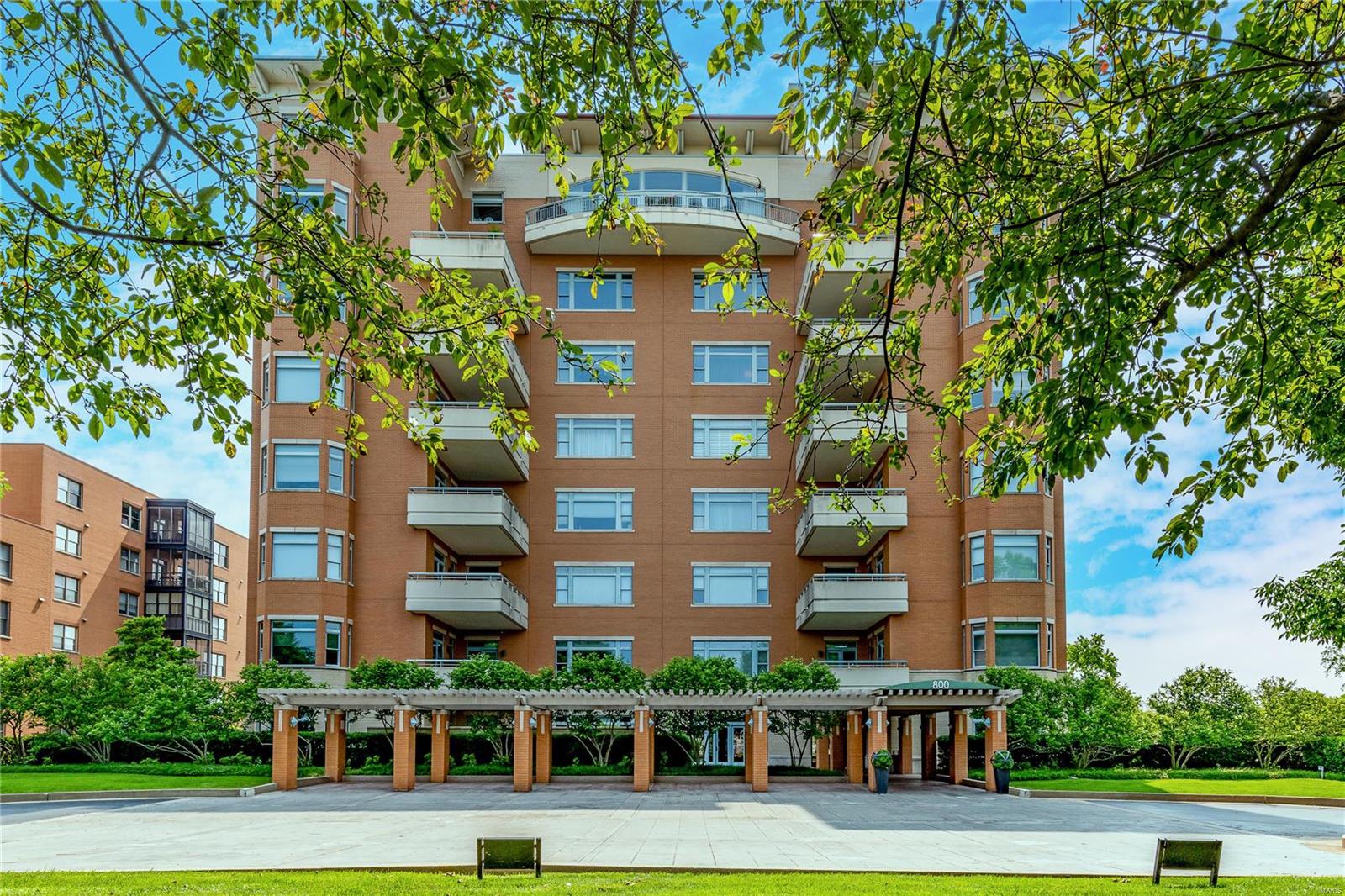 Stunning condo located in one of Clayton’s most popular and well-managed buildings. There has never been an additional assessment. On-location manager and exemplary doormen and staff. This unit was custom designed by the original owners. You will notice the 3-tiered crown molding, gorgeous wood floors and custom built-ins. The living area is bright and spacious. The casual den could be a formal dining room, though the owners wanted the dining room to be in the spacious main living area. The eat-in kitchen features granite counters and abundance of floor to ceiling custom cabinets.  You will love the breakfast area near a large window and access to the balcony off of the kitchen- a perfect outdoor area to enjoy your flowers & to grill.  The 2nd bedroom has a built-in desk and Murphy bed for guests. The primary bedroom is spacious with ample walk-in closet space and a bathroom with dual vanities, granite counters, jetted tub and separate shower. 2 adjacent parking spots. Great amenities! Location: City