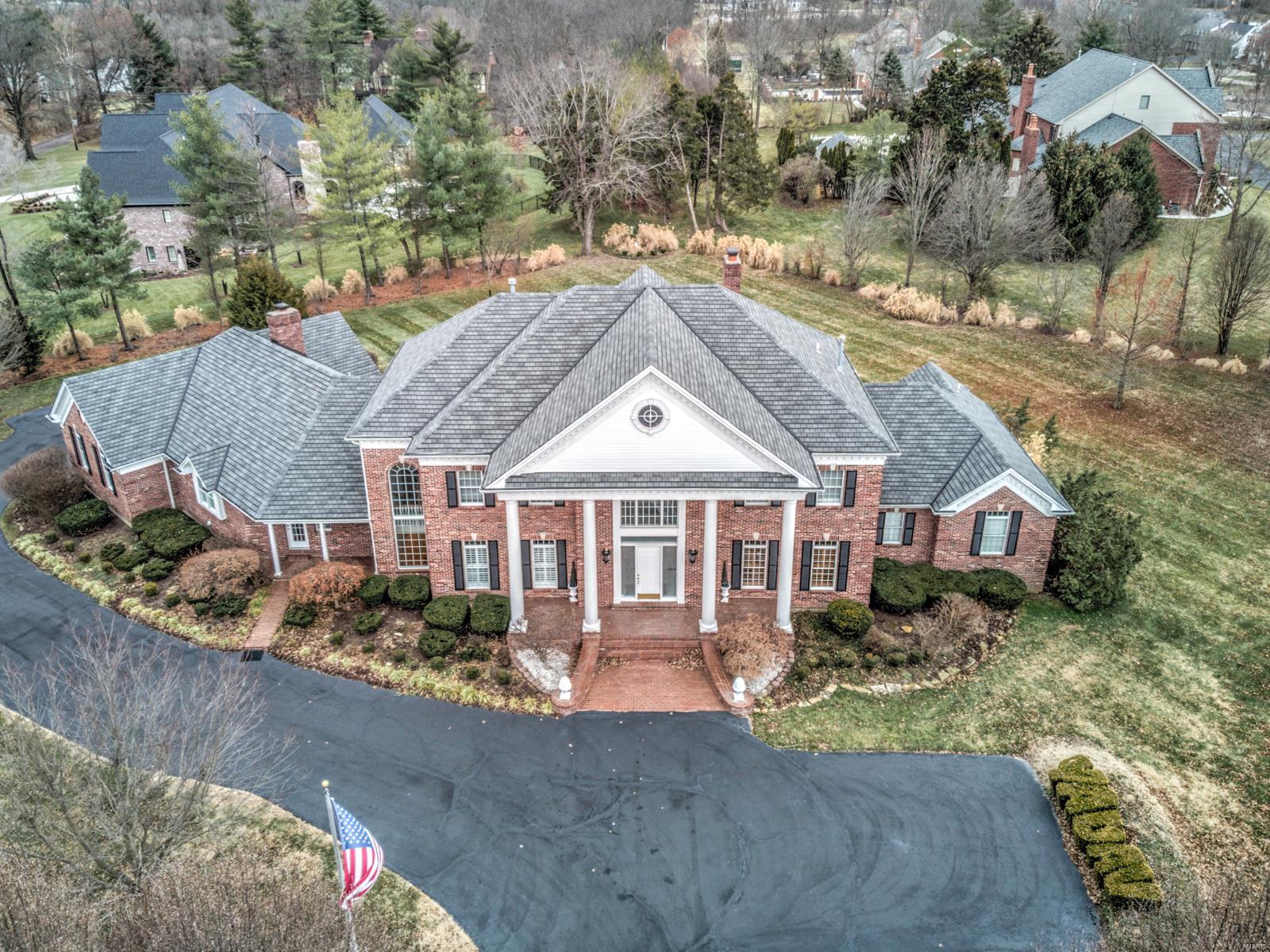 Magnificent residence in a quiet gated community. All brick construction. Built by Rehnquist. Level two-acre lot with mature trees, gardens, and fountains. Two story entry foyer with curved staircase. Two story great room with window wall and wet bar. Gourmet kitchen with center island, granite countertops, high-end appliances, and walk-in pantry. Luxury master suite with 10' coffered ceiling, two walk-in closets, vaulted bathroom, walk-in shower, soaking tub, and dual vanities. Hearth room with floor-to-ceiling brick fireplace. Finished lower level with office, gym, media room, sunken living room, game room, bathroom, cedar closet, sauna, wet bar, full kitchen, stone fireplace, and recessed lighting. Large main level laundry room. Nine foot second level ceilings. Four car garage with man door and private stairs to basement. Extensive mill-work. Central vacuum. Dual covered front porches. Large patio. Circle drive. Quick access to 40 and 270.
