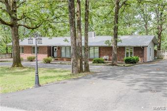 BEST LOCATION IN Waynesville/St. Robert!  This 4 bed, 2 bath Ranch style homes is located in one of the most ideal, established neighborhoods in the area. This spacious home has a huge circle driveway and front deck with built-in benches that can easily turn into planter boxes, BRAND NEW WOOD LAMINATE floors in the living room and bedrooms, new recessed lighting, a new metal roof less than 5 years old and a new A/C unit outside.  Inside you will find a gorgeous floor to ceiling fireplace and floor to ceiling windows in the living room.  HUGE kitchen that can accommodate a dining table or can be re-configured to suit your personal taste.  There are two living areas, one with built-in book shelves, Master Suite with dual vanities, a sun room with French Doors that leads to the deck and a HUGE fenced-in back yard. This home is completely move-in ready, however also has endless possibilities if its new owner is looking for a house to renovate!! Additional Rooms: Sun Room