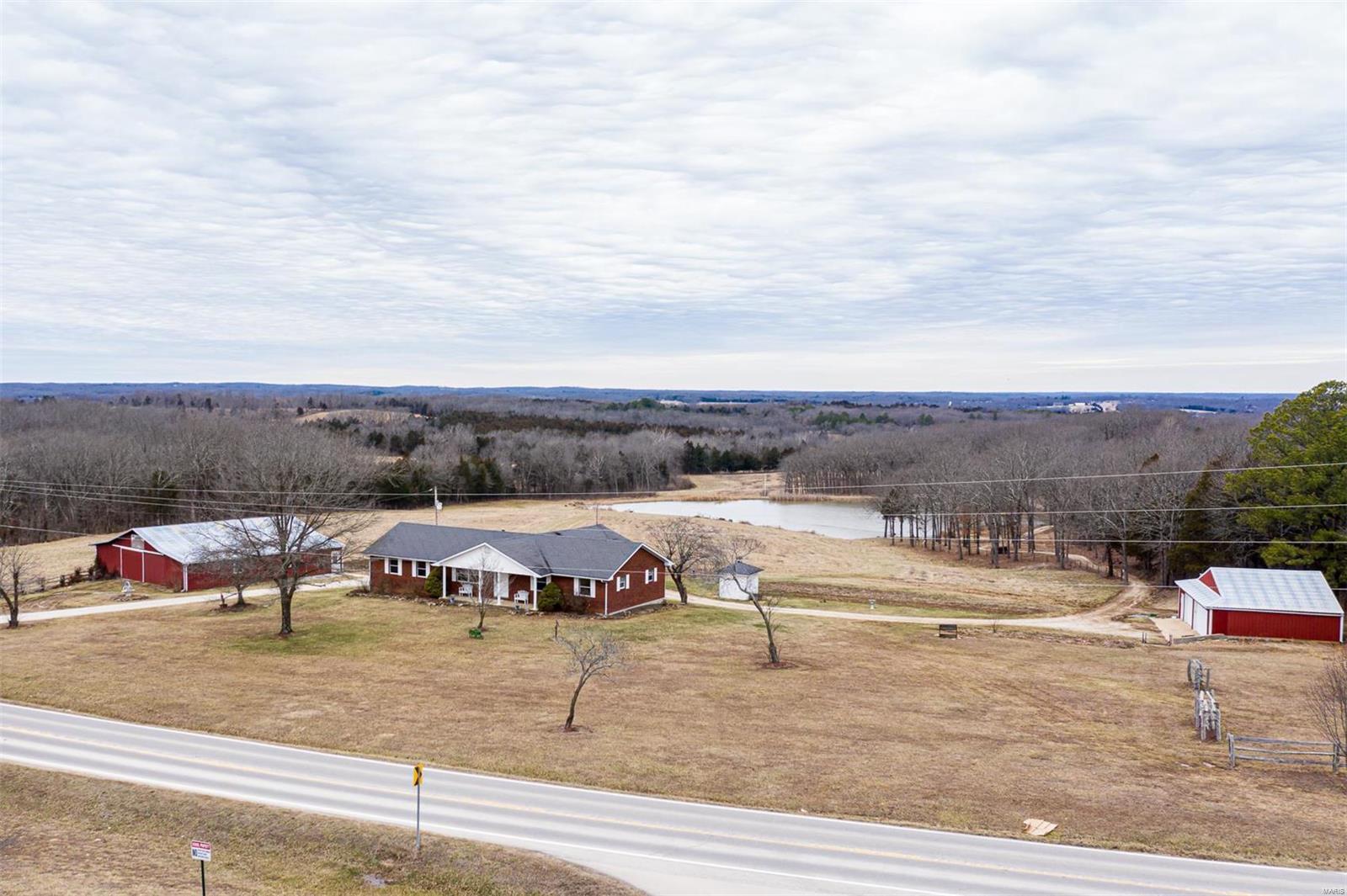 Here is a fresh canvas to make this 3 bedroom 2 bath ranch your own. There is a limited supply for property such as this desirable 25.44 ACRES with 2.5 acre STOCKED LAKE, detached 3 car garage, with work shop space, approx 60x52 COW BARN, with 2x4 rough cut wood, stalls, loft, has water & equipment storage. There is also a smoke house & chicken coop. Endless beautiful sunsets available from the suspended concrete covered patio. Quality, owner/contractor built ranch offers 1296 sq ft on the main floor that is ready for you to finish to your own tastes. 2 car garage, full walk out basement, partially finished with a sleeping area, family room, 2nd kitchen/dining area & an additional multiple use work space with concrete ceiling, plumbed for water & walk out to back patio. This gorgeous property also has a cabin by the lake with its own well, property is mostly fenced, so bring cattle, horses, & other livestock. One of a kind, opportunity, located in a great location, black top roads.