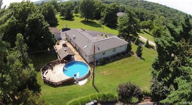 This stunning ranch home sits on 1.2 private acres in the Lindbergh School District and boasts many unique design features throughout. Professional landscaped grounds, a large circle driveway, and 3 car detached garage. 4 large bedrooms & 3 full bathrooms, 2 main floor laundry areas (one in the master closet), living room with built in shelving and fireplace, and family room. Large kitchen with granite countertops and plenty of storage space. Walk outside from the dining area and be ready to entertain in style. Beautiful patio with covered pavilion, firepit, and a large deck surrounding the pool. The master bedroom suite has amazing architectural details. You'll love the custom bathroom featuring a large walk in shower & separate Jacuzzi tub and his/her vanity & closets. Basement is clean, dry, and unfinished featuring plenty of ample storage space or additional future living space if needed. This is one you must see in person to appreciate all the fine details and custom designs.