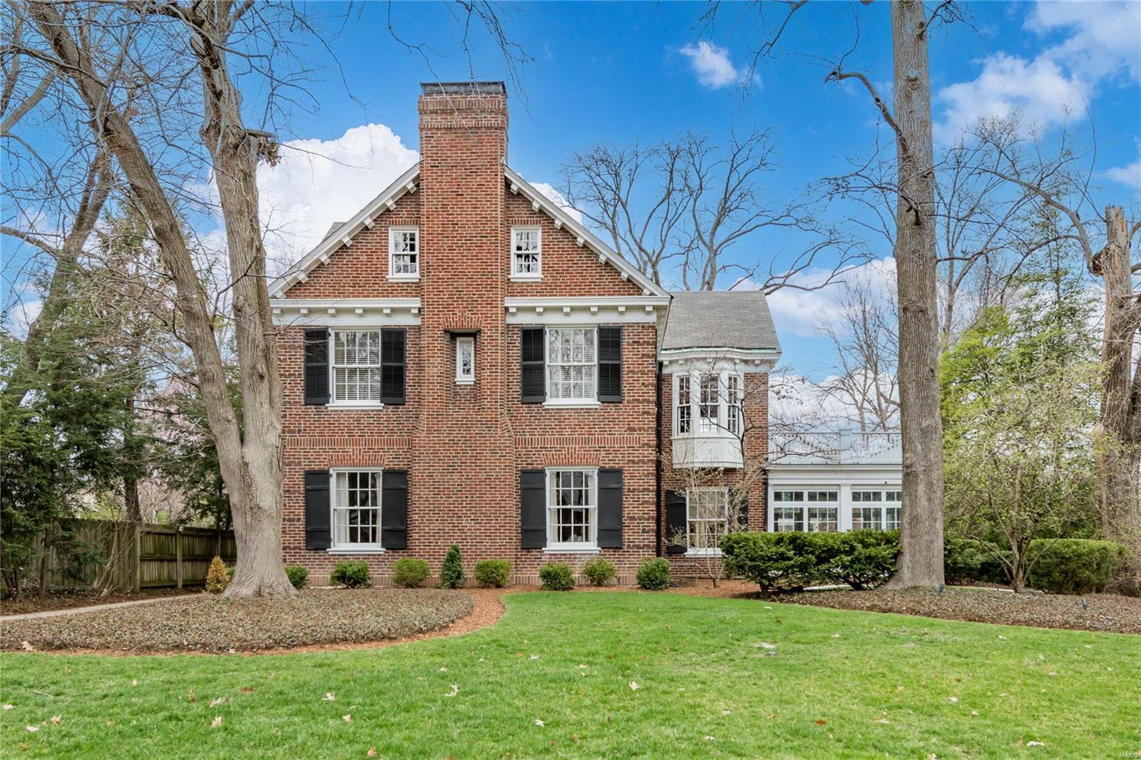 This beautifully updated home originally built for Mr Edward Jones in 1925 is located in one of Claytons most desirable neighborhoods. The remarkable architectural detail has been carefully preserved throughout the home. The modern updated kitchen opens to a large family room with French doors that leads to the back gardens and outdoor living area with built-in bar and grill.  The dining room opens to a newly enclosed three seasons sunroom with surround views of the patio and yard.  Near the front of the home is a gracious living room with fireplace and built in book cases. The primary bedroom suite is located on the 2nd level with double vanities, jetted tub, separate shower and large walk-in closet. 2 additional en-suite bedrooms and laundry are located on the 2nd level.  The additional 2 bedrooms and full bathroom and are located on the 3rd level of the home. 3-car garage. Additional Rooms: Mud Room, Sun Room