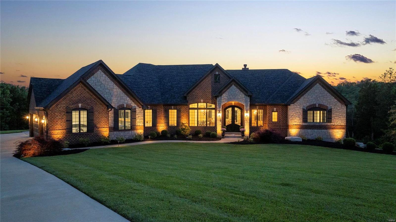 RESORT STYLE LIVING in West County! Custom built sprawling ranch nestled within a private subdivision minutes from Wildwood Town Center. The 7,010 sq/ft. home designed for its three acre lot is lined with a gorgeous backdrop of trees. Notice the gorgeous
12-foot great room coffered ceiling, both floor to ceiling stone fireplaces and three piece crown molding on main level. Cotton candy like sunsets viewed from the 3,000 sq/ft Belgard pool deck gives a feeling of paradise. Enjoy the oversized saltwater pool w tanning ledge in summertime heat. The gunite pool features include: two fire bowls, a fountain wall with five waterfalls and both a heater and a chiller.  Engage in conversation around the rectangular stone gas fire pit.  Open the French doors to the fully finished basement and enjoy the 85" TV.  Take note of extra backyard space ideal for sport court, pool house, or even in-law studio. Brand new $52,000 architectural shingle roof installed April 2024. 16 ft extra wide driveway. Additional Rooms: Mud Room COOL: 14 SEER+