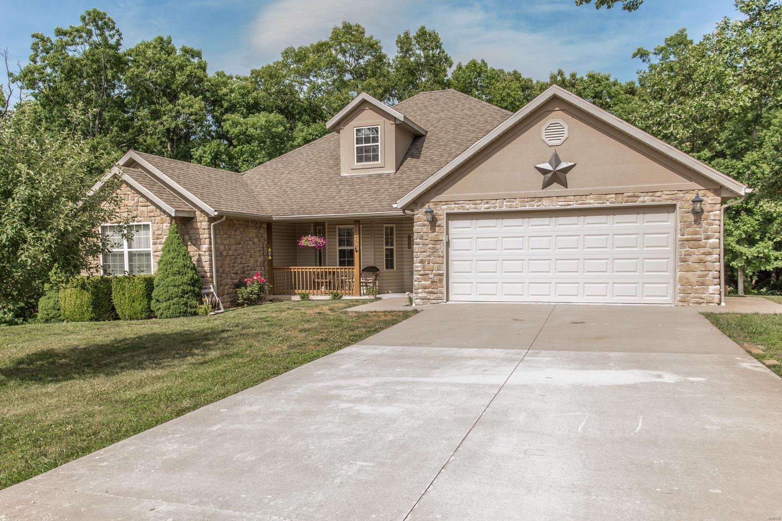 This house has it all! Driving up you'll notice the large lot that backs to trees, pristine landscaping and darling curb appeal, gorgeous covered deck and pool makes for your own private retreat. Walk inside to an open floor plan with beautiful wood floors, vaulted ceilings, huge updated kitchen, rock fireplace, and a popular split design for the bedrooms. Downstairs is a finished walkout basement with new floors in the main area, additional large bedrooms, and tons of storage. This home is everything you've been looking for and more!