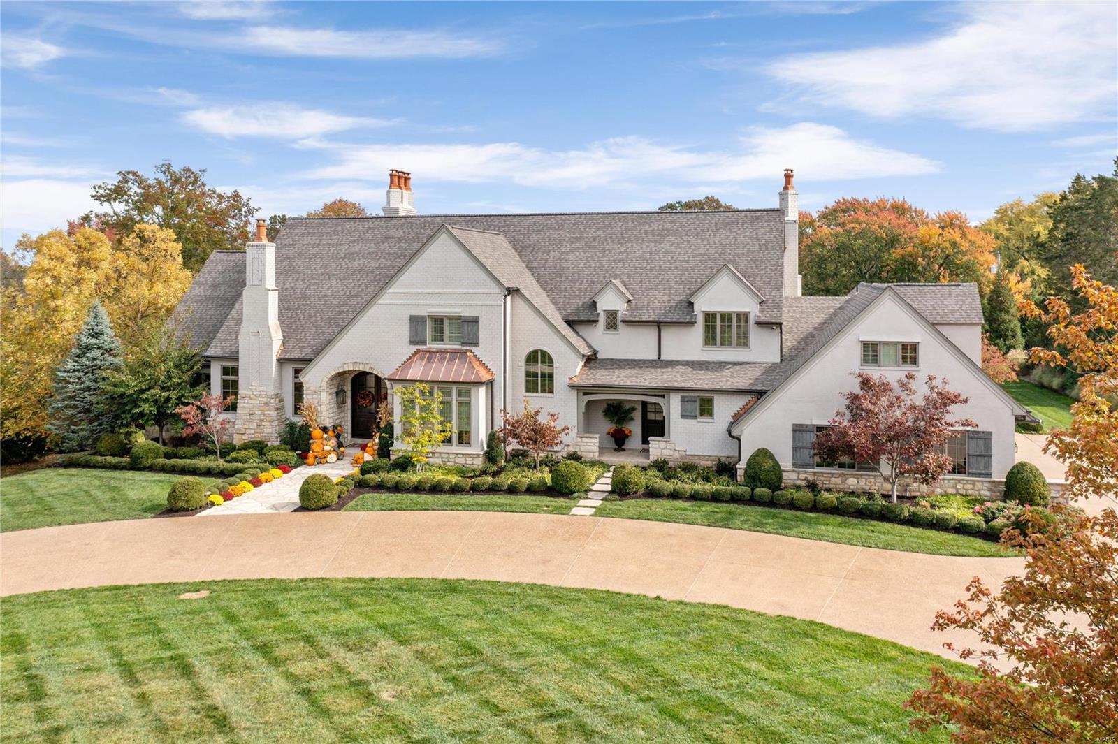 This European-style Estate home embodies timeless architecture, uniting brick, stone, and stucco. The travertine marble foyer leads to a private study with a stone fireplace and custom built-ins, an elegant dining room, and a great room with hand-hewn beams and a floor-to-ceiling fireplace. The designer kitchen features quartz countertops and commercial-grade appliances, adjoining a sunlit breakfast room and a vaulted hearth room with a soaring fireplace. The coffered master bedroom suite offers a stone fireplace, a bow window, and a marble bath. Front and rear staircases provide access to four ensuite bedrooms, a bonus room, and second-floor laundry. The lower level includes a recreation room with a bar and wine cellar, game room with fireplace, media room, bonus room, workout room, and a full bath. On a 3-acre lot, the property features an outdoor living room with a grill and fireplace, a pool house with a bar, and a resort-style pool amidst landscaped gardens. This is Home. Additional Rooms: Wine Cellar