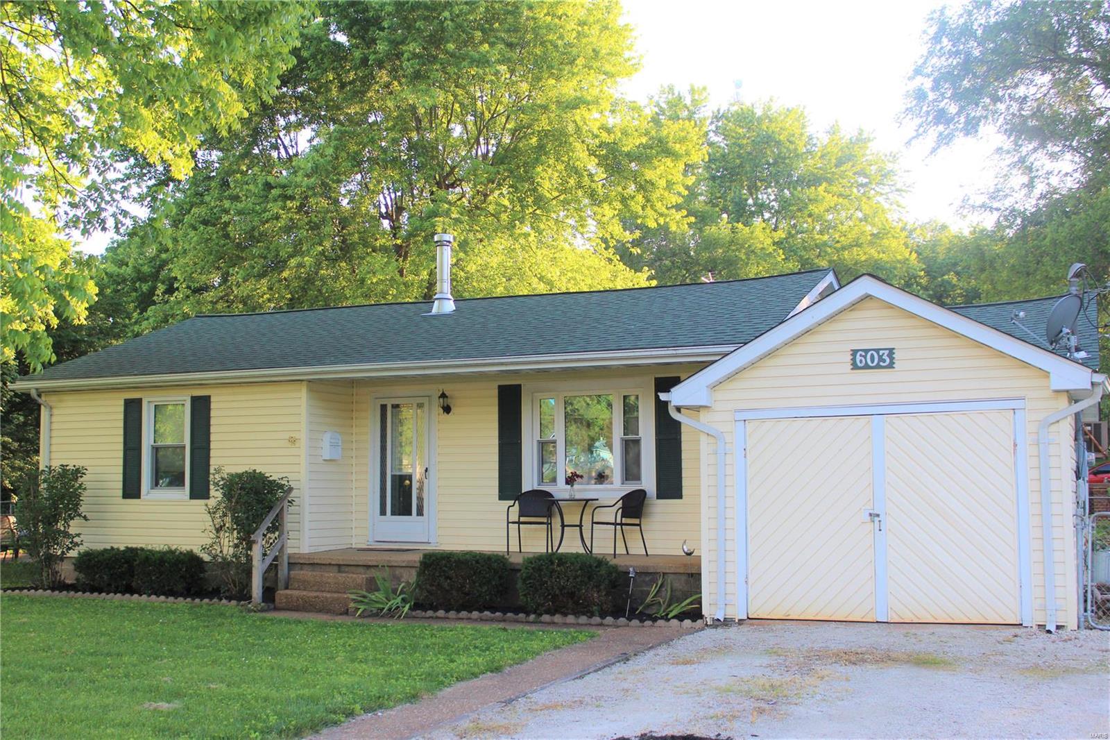 This charming home is perfectly situated on a corner lot with lots of space to entertain. Step inside to enjoy the spacious living room accented by the wood burning fireplace. The updated kitchen offers ample storage, counter space and beautiful colors. Enjoy your coffee in the separate dining room looking out to the large backyard. Two bedrooms and an updated bathroom finish off the interior of the home. The laundry/utility room leads to the oversized garage. Spend the rest of your summer entertaining on the new patio and fenced in level yard. All of these great features are awaiting new owners.