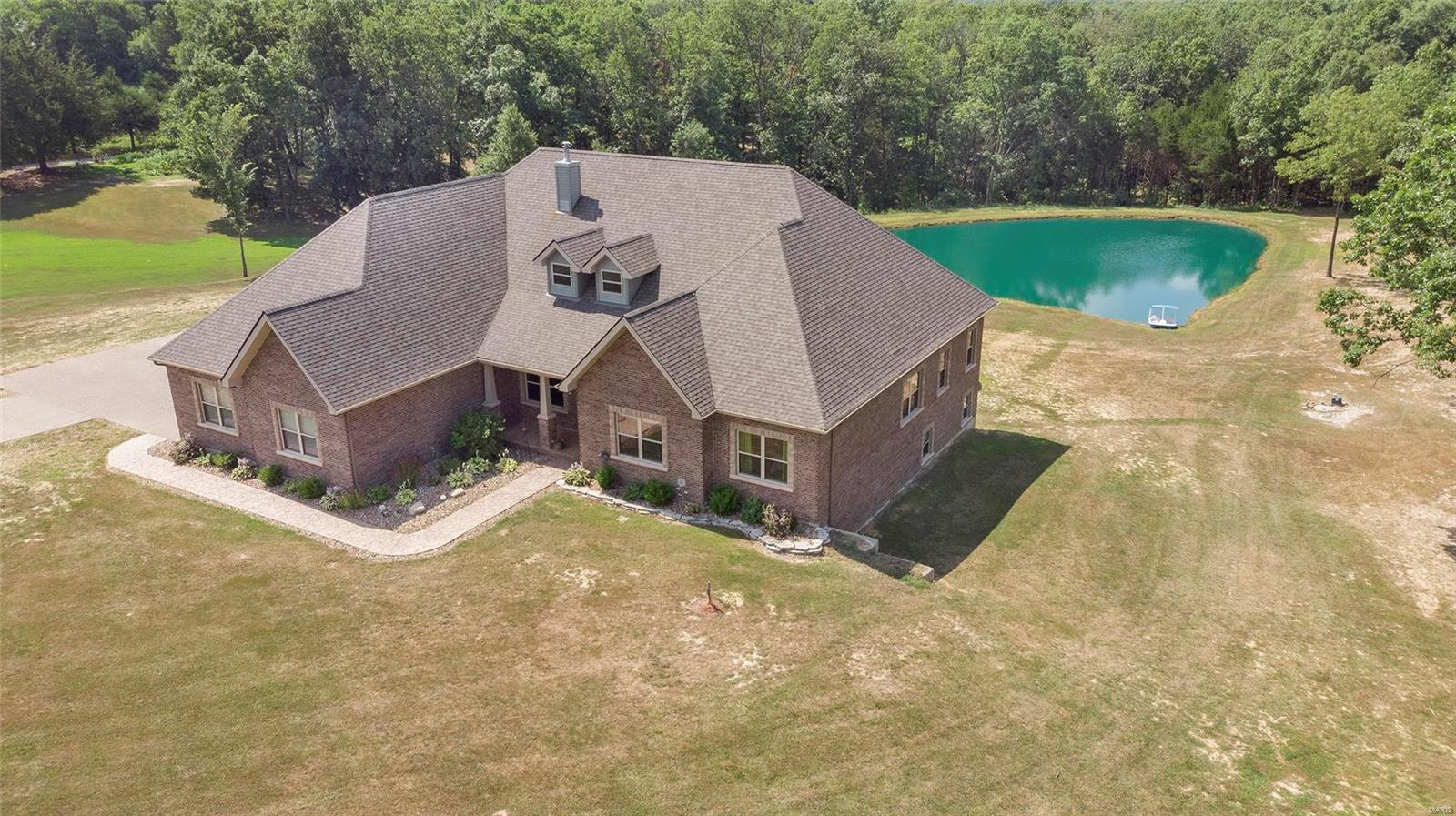 Impressive ranch home located in the desirable New Melle Area*This open, spacious floor plan is inviting & warm*From the entry to the kitchen beautiful engineered hardwood floors greet you*You will enjoy entertaining in this expanded vaulted great room (with room for a dining table if you so desire) that's open into the breakfast room & fully equipped kitchen with stainless appliances*Tons of staggered height cappuccino cabinetry with crown molding, granite counter tops, back splash, breakfast bar, walk-in pantry, laundry room with half bath & exit to covered low maintenance vinyl deck overlooking the pond*The massive Master bedroom has en suite with dual vanities, whirlpool & step in shower*The lower level is finished with a huge family/rec room, 2 more bedrooms, full bath, a tuck under garage (perfect for lawn equipment) & a walk out to covered patio*A 3.77 ac stand alone lot*No known restrictions*The lovely stocked pond is peaceful to watch whether you are relaxing or fishing*