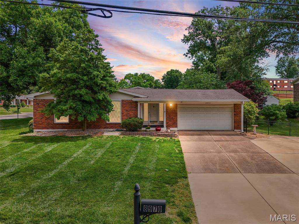 Welcome to this spacious and well-maintained ranch home perfectly located within walking distance of Grant's Farm. Offering 3 bedrooms and 2 full bathrooms on the main level, this home features exposed hardwood flooring, fresh interior paint, and updated light fixtures throughout portions of the home. The main level includes a large living room, separate dining area that could also serve as a formal sitting area, and a screened-in porch/sunroom overlooking the fenced backyard and side yard. The finished lower level provides additional living space with a spacious family room, large laundry room, full bathroom, and two additional rooms that could serve as sleeping areas, offices, hobby rooms, or flex spaces. An attached two-car garage offers convenience and additional storage. This home offers additional peace of mind with a all home generator! Conveniently located near shopping, dining, parks, and major commuter routes, this home combines generous living space, functional updates, and an excellent location. Don't miss this opportunity to make it your own.