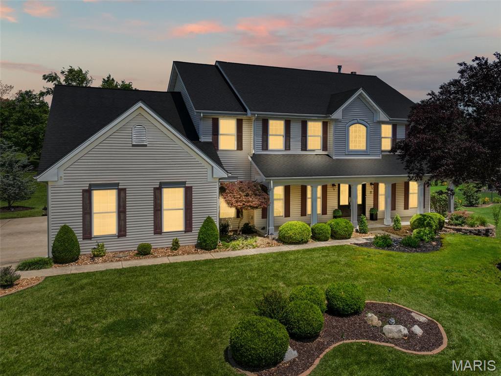 Set on a beautifully landscaped lot of nearly half an acre, this 4-bedroom, 4-bath home combines quality finishes, generous living spaces, and a floor plan designed for everyday living.

A welcoming covered front porch and impressive two-story entry create a memorable first impression. Just off the foyer, French doors open to a private office, providing the perfect space to work from home. The spacious living room features custom built-in bookcases surrounding a gas fireplace, while hardwood flooring flows throughout much of the main level.

The kitchen is truly the heart of the home and is designed for both everyday living and entertaining. Highlights include a large center island, granite countertops, high-end Wolf appliances, a gas cooktop, double ovens, warming drawer, Sub-Zero refrigerator, abundant cabinetry, and a bright breakfast area. The adjoining hearth room features hardwood flooring and a second gas fireplace, creating a comfortable gathering space. Just off the breakfast area, sliding doors lead to the aggregate concrete patio complete with a gas line for grilling and overlooking the private backyard.

Upstairs, you'll find four generously sized bedrooms, including two ensuite bedrooms, three walk-in closets, and a versatile bonus room that could serve as a playroom, media room, home office, exercise room, or potential fifth bedroom.

The thoughtfully designed floor plan also includes both front and rear staircases, a convenient main-floor laundry room, and a side-entry 3-car garage.

The unfinished lower level offers excellent storage and future living space potential, with a bathroom rough-in already in place and ready for your finishing touches. For added peace of mind, the seller is offering a one-year home warranty.

Located in the highly rated Ft. Zumwalt School District and just minutes from Highway N, Highway K, and Interstate 64, this home offers the space, features, and setting that are increasingly difficult to find in today's market.