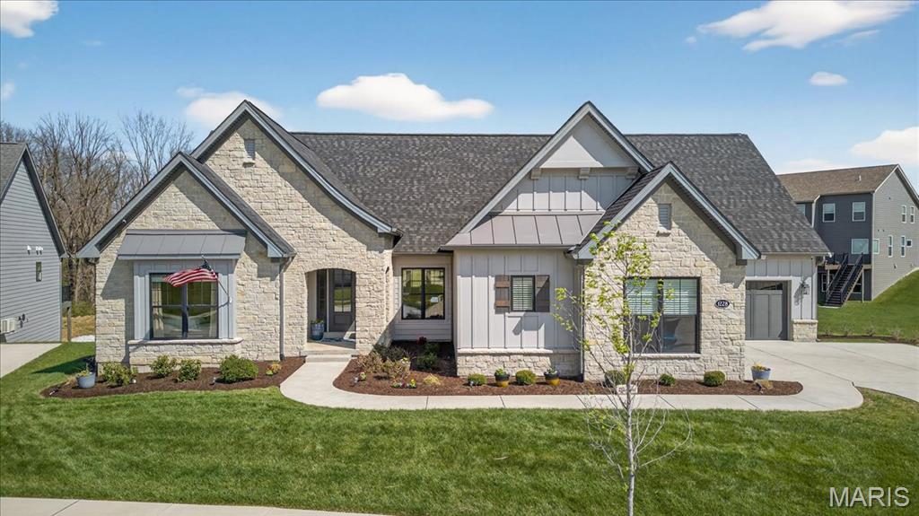 Welcome to 1228 Gooseberry Lane, where custom design, thoughtful upgrades, and everyday comfort come together in one exceptional Chesterfield home. Built in 2022 and set on a premium walkout lot, this ranch-style residence offers a rare blend of luxury, functionality, and effortless living. From the moment you step inside, the attention to detail is undeniable. Engineered hardwood flooring, oversized solid core doors, and curated lighting create a refined yet welcoming atmosphere. Every finish throughout the home, from the trim colors to the fireplace tile, backsplash, and bathroom tilework, was thoughtfully selected in collaboration with a professional designer, resulting in a cohesive, elevated aesthetic at every turn. The main level is designed to flow beautifully, offering a formal dining room, expansive great room, and a warm, inviting hearth room, all seamlessly connected to the heart of the home, a stunning chef’s kitchen. Featuring quartzite countertops, Jenn-Air professional appliances, a 156-bottle wine refrigerator, and extensive custom cabinetry throughout, including the kitchen, butler’s pantry, and beyond, this home offers exceptional storage without compromising style. Sonos speakers are thoughtfully integrated throughout the home, creating a seamless and elevated audio experience for both everyday living and effortless entertaining. The primary suite is a true retreat, privately positioned with direct access to the oversized deck. Inside, you will find a spa-inspired bathroom complete with heated floors, a luxurious two-person shower, soaking tub, dual vanities, and separate his-and-hers closets with custom organization systems. Every bedroom on the main level offers its own ensuite with zero-entry showers and designer finishes, creating comfort and accessibility without compromise, ideal for aging in place. The walkout lower level expands the home in a way that feels intentional and complete, offering an additional bedroom and full bath, multiple living and entertaining areas, a theatre room, gym, private office, wet bar, and even a four-season room with exterior ventilation. Whether hosting guests or enjoying a quiet night in, this level was designed to accommodate it all. Beyond the interior, the upgrades continue. An oversized deck with underdecking overlooks the enlarged patio and professionally enhanced outdoor space, complete with a jacuzzi, outdoor lighting, and invisible fence. Smart home features, including thermostats, lighting, security, irrigation, and more, provide convenience and control at your fingertips. Additional highlights include a heated, epoxy-finished garage with EV-ready outlets, upgraded 400-amp electrical service, enhanced insulation for energy efficiency, a new roof (2025), and extensive builder and post-construction upgrades. Beyond the home itself, you will find yourself immersed in the lifestyle of Fienup Farms, one of Chesterfield’s most sought-after communities. Designed with connection and recreation in mind, residents enjoy the large lake, scenic walking trails, pickleball courts, and playgrounds, all while benefiting from a low-maintenance lifestyle with landscaping (mowing, fertilizing, mulch, and trimming) and snow removal included, allowing you to spend more time enjoying your home and less time maintaining it. This is more than a home, it is a fully realized living experience, where every detail has been carefully considered and every space designed to elevate the way you live.