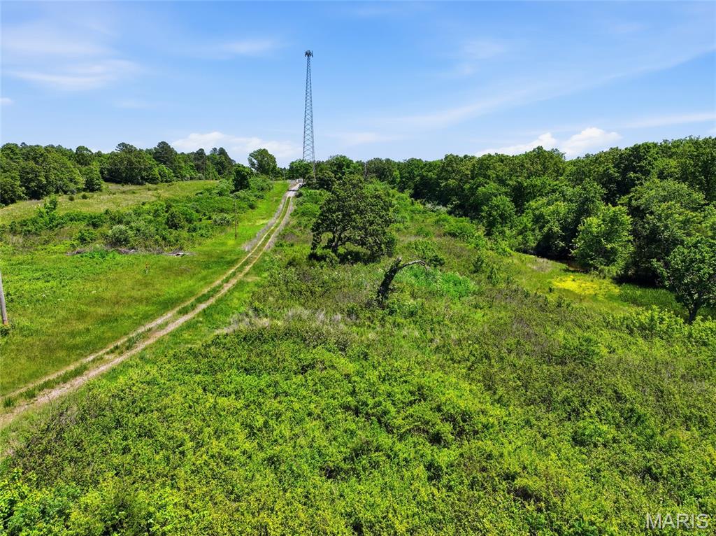 Very nice 12.5 acres of land with no restrictions. Located on blacktop with the entrance off dirt. There was a fiber optic tower placed at the very top of this property years ago, with a nice entrance road placed making it easy access for a build. There is an old well and electric available on the property. The well has not been used in many years but is still present. Rural water is also possible. There is evidence of large bucks running through this property and there is a small pond located at the corner. Across the road is a small parcel that completes the 12.75 acres but can be bought separately or this parcel can be purchased separately. Parcel is completely perimeter fenced. Owner financing available with 20 percent down.