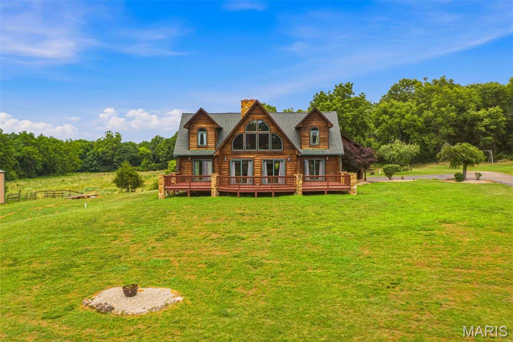 Escape to your own private river retreat with this stunning 3 bedroom 3 1/2 bath log home nestled on 28 m/l breathtaking acres. Surrounded by nature and offering unmatched privacy, this property is the perfect blend of of rustic charm and modern comfort. This property borders the Big River providing a beautiful place to swim and float! Step inside to find a warm and inviting family room anchored by a gorgeous stone pass thru fireplace, perfect for cozy evenings. The finished basement add a valuable living space, bonus bedroom and features its own striking stone fireplace. Enjoy the beauty of the outdoors with the oversized deck and large porch both offering beautiful view of the countryside. A serene pond enhances the landscape. This property also includes large outbuilding, perfect for storage, hobbies or workshop space.