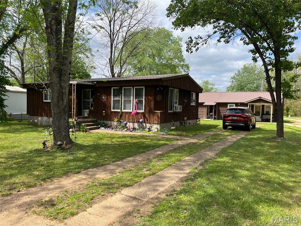 Three residences on one city lot in Piedmont MO. There's enough room for all the relatives or continue as an income with the current tenants. #310 is a doublewide with 2-bedrooms, 1-bath, central h/a, all appliances and covered front and back porches. There are also two 1-bedroom cabins. #316 cabin was built in 2023. #312 cabin has been completely remodeled. Both cabins are on a concrete slab with front porches and include stove, refrigerator, washer and dryer. Storage shed included. All units have city utilities on a level, shaded lot.