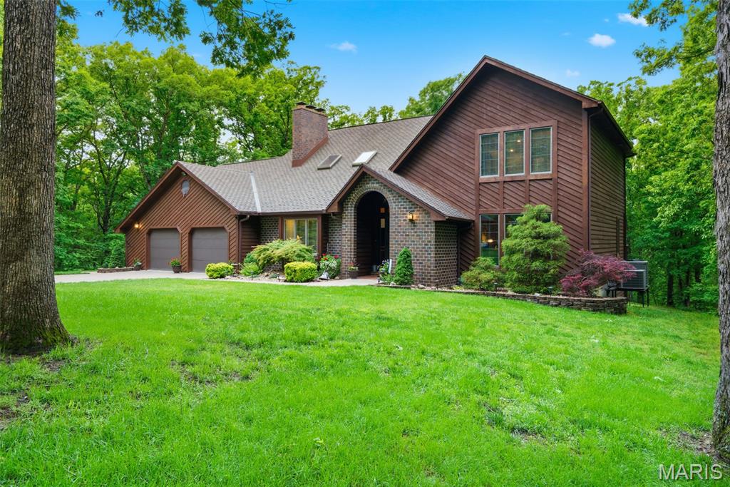 Escape to this beautiful 4-bedroom, 3-bathroom home nestled on 9 acres of serene, wooded land. Enjoy the tranquility of nature with hiking trails winding through your private property and access to a shared lake, perfect for fishing or relaxation. Inside, the fully renovated luxury kitchen features exquisite granite countertops, ideal for culinary enthusiasts. The spacious family room boasts vaulted ceilings and two cozy fireplaces, creating a warm and inviting atmosphere for gatherings. With charming cedar siding and a detached garage workshop, this home perfectly blends comfort and functionality. Don’t miss the chance to own this private retreat!