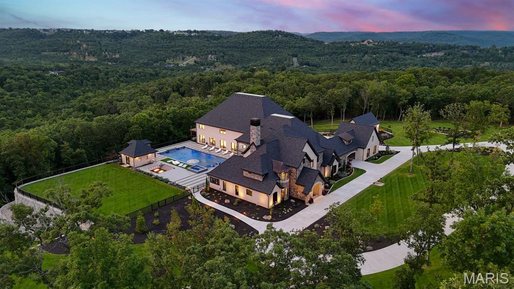 Thoughtfully repositioned, 300 Ridgecrest Drive presents a rare opportunity to own one of the Ozarks' most remarkable private estates. 

Set on more than 10 secluded acres in Saddlebrooke, Missouri, surrounded by the pristine beauty of the Mark Twain National Forest, this Modern European compound offers multiple outbuildings and an extraordinary collection of amenities. 

Completed in 2023, the property boasts a 7,920-square-foot residence and an impressive 5,700-square-foot sports-and-entertainment pavilion featuring an NBA-rated basketball court, a gym, and flexible event space. 

Timeless architectural materials—stone, brick, timber beams, and reclaimed wood—pair seamlessly with advanced smart-home automation, magnetic-lock security, and automated blinds and screens. Inside, soaring ceilings, multiple chef's kitchens, refined finishes, and gracious entertaining spaces are complemented by a private theatre and arcade. The primary suite is a true retreat, complete with a fireplace, spa-inspired bath, and a sunroom featuring a private plunge tub and a swing bench. Furnished with Restoration Hardware pieces, the home embodies warmth, elegance, and contemporary comfort. Outdoor living rivals a private resort, highlighted by a 70-foot beach-entry pool, a 12-person spa, a pool house, firepit lounges, and a fully equipped outdoor kitchen with a pizza oven, commercial grill, and refrigeration. 

Additional features include RV accommodations, a motorized gated entry, an expansive motor court, and a private go-kart track. Located just minutes from Branson, Springfield, and Table Rock Lake, this exceptional estate delivers an unparalleled blend of privacy, recreation, and luxury.