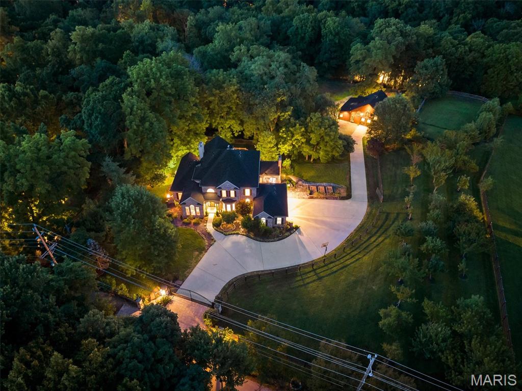 This estate is known as La Fermette. This is a one-of-a-kind, GATED, EQUESTRIAN PROPERTY resting gracefully on 3+/- acres providing a peaceful & tranquil atmosphere in the HEART of CHESTERFIELD with an EXQUISITE CUSTOM 1.5 home, STATELY 60x40 cedar Barn Pro barn with 4 stalls, a half bath, and a separate wood working area, outdoor riding arena, detached 2-car garage, attached 3 car garage & BEAUTIFUL, MATURE, fruit producing pear, peach, cherry, & apple trees, and a grape vineyard! 5,823+/- SqFt, 4 bedroom, 4 full & 1 half bath home, PLUS Au Pair/in-law suite. Hardwood oak flooring throughout most of home. A grand 2-story entry foyer welcomes you. Great room features an 18’ ceiling w/balcony from 2nd floor, gas fireplace, wet bar, bookcases & a wall of windows allowing plenty of natural light & stunning views of the property. Eat-in kitchen flaunts custom cabinetry, granite counters, center island, stainless steel appliances, Subzero built-in fridge/freezer, 2 walk-in panties, second staircase to upper-level & walk-out to large, private deck with hot tub surrounded by trees. Main level primary suite, boasts 2 custom walk-in closets, French door entry to office and GLAMOUROUS updated MARBLE accent bath with heated floors, custom vanities, walk-in shower, freestanding tub and private commode. Completing the main level living space is an office, dining room, hearth room, laundry room and a half bath. Upper level extends living quarters with 3 additional bedrooms, 1 has ensuite bath & other 2 share Jack-n-Jill. Walk-out, lower level extends living quarters, GREAT for an Au Pair/IN-LAW suite, that features: large rec room, 2nd kitchen, living room w/gas fireplace, Au Pair/in-law suite w/custom closet, 2nd laundry *stackable only*, dog spa w/grooming table & 3rd laundry *stackable only*, full bath & un-finished storage room. MUST SEE!