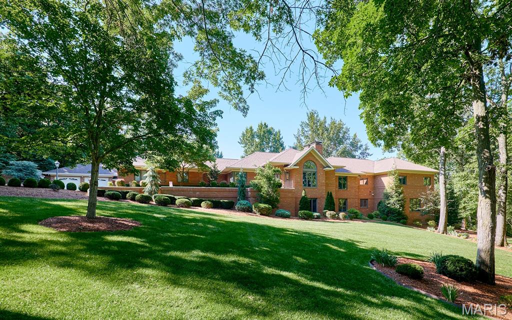 3 Forest Hills Drive is an executive estate created for buyers who expect quality, privacy, and luxury. Set on 7 manicured acres, the residence offers more than 7,000 square feet of finished living space and full brick construction on all four sides.

High-coffered ceilings, beautifully refinished hardwood floors, and two stories of windows overlooking the property create a living space that is impressive yet comfortable. A floor-to-ceiling brick fireplace anchors the vaulted living room, while Andersen 400 Series windows bring in natural light and frame the views. Hunter Douglas PowerView shades and new Therma-Tru exterior doors with triple-lock systems add security throughout.

The completely remodeled kitchen serves as the center of the home. A massive island with Cambria countertops provides workspace and seating, while the gas cooktop, built-in oven, cabinet-faced refrigerator, large pantry, and generous cabinetry all project quality in every detail. Enjoy mornings in the breakfast room surrounded by windows or entertain guests in the formal dining room. The open layout and cascade of natural light create an easy, yet refined flow throughout. Arched doorways, crown molding, and wainscoting add refined detail.

The massive primary suite is a private retreat with a sitting area, a private covered deck, and two spacious walk-in closets. The fully renovated bath offers a massive soaking tub, a large dual-headed walk-in shower, two separate vanities, and a private commode. Two additional bedrooms with ample closet space are also located on the main floor, along with a renovated hall bath featuring a private shower and separate soaking tub. A dedicated main-floor laundry room adds convenience.

The walkout lower level expands the living and entertaining space. Two additional bedrooms and a full bathroom accommodate family or guests, while a private office offers a quiet place to work. The family room includes a second fireplace, a wet bar, and a pool table for casual entertaining. The huge recreation room offers space for gatherings, games, fitness, hobbies, or a private theater. Three sets of French doors lead outside to the expansive patio and backyard.
One of the home’s most distinctive features is the climate-controlled wine cellar and vault. Custom wine storage, dedicated environmental controls, and a substantial safe-style door create an exceptional space for serious collection and secure storage.

The attached three-bay garage provides parking and storage, while a separate air-conditioned garage adds versatility. With two oversized doors and a workshop area, it is ideal for a collector, craftsman, recreational equipment, or additional vehicle storage.

The home is equipped with dual geothermal systems and a 48 kW Kohler whole-house generator. Improvements include a new five-bedroom septic system and drain field, extensive well upgrades, new pressure tanks, a 1,000-gallon propane tank with new gas lines, updated electrical panels, wired Wi-Fi, security cameras, integrated audio and visual systems, exterior lighting, gutter guards, tuckpointing, and added storage.

The 7± acres lay like a private park, open and usable while shaded by large, mature trees. Two gazebos and an extensive multilevel patio create multiple outdoor gathering spaces, while the broad backyard offers room for family events, for children to run, for pets to play, or for a future pool.

3 Forest Hills Drive delivers the space of a true estate, the quality of a full-brick custom home, and the modern systems expected by today’s luxury buyer. With refined living spaces, five bedrooms, exceptional entertaining areas, multiple garages, a serious workshop, and a climate-controlled wine cellar and vault, this property was built for the buyer who demands more and refuses to settle for ordinary.