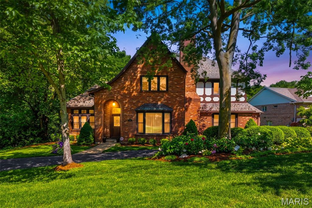 Open House Sunday 8/2 1-3 PM!! This magnificent brick Tudor-style estate resides across the street from Watson Trail Park and sits on a breathtaking, private 0.51-acre wooded lot in prestigious Sunset Hills, truly your own private botanical garden oasis. Boasting an impressive 5,356 square feet of luxurious living space, this home showcases timeless elegance with exceptionally spacious, generously proportioned rooms throughout.
The main level impresses with a massive living room featuring a cozy fireplace, an equally expansive family room with fireplace and convenient half bath just off it, formal dining room perfect for entertaining, and a gourmet eat-in kitchen complete with a large breakfast bar, center island with prep sink, and electric cooktop. Additional main floor highlights include a dedicated office, a sunroom with built-in hot tub, and convenient main floor laundry. Rich oak woodwork, soaring beamed ceilings, and extensive custom built-ins add warmth, character, and sophistication.
Upstairs, the  large primary bedroom suite offers a luxurious primary bath, complemented by three additional very spacious bedrooms and a full bathroom. The huge walk-out basement features a full bath, providing exceptional flexibility for recreation, guests, or future expansion.
Step outside to enjoy the expansive deck and patio overlooking the serene, lush backyard, an entertainer’s dream in a peaceful, park-like setting.
Nestled in the highly sought after Lindbergh School District, this exceptional residence offers the perfect blend of classic Tudor charm, modern comforts, and resort-like private grounds. A truly rare opportunity. Welcome home!