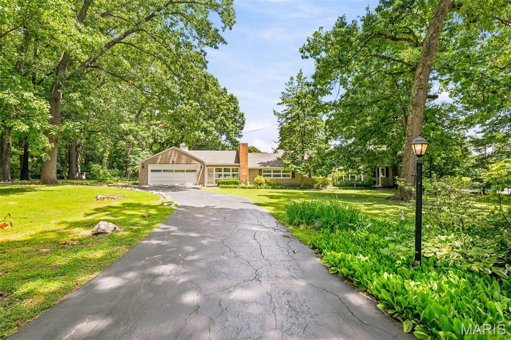 Want to wake up every morning, look out your back window and see nothing but woods, yet still be in the heart of St. Louis County? Then don't miss out on this very special mid-century ranch, offering 3 acres of land, nearly 2700 SQUARE FEET of finished living space, and a sparkling inground pool just waiting for summer fun! This 1948 gem has been in the same family since 1956 and many of the original vintage features still shine through, including knotty pine paneling, colored tile bathrooms, built-in cabinets, 3 fireplaces and a charming retro kitchen. There's also a main floor laundry, HUGE garage, spacious courtyard patio and a partially finished basement with egress window....potentially another bedroom or sleeping area. In years past, the lower part of the backyard was actually a horse pasture, and if you wanted to, you could still have one horse here today. Chickens too. Basically, this is the "country property" of your dreams, barely 15 minutes from Clayton, listed for less than $300k. What a find! The roof is less than two years old. One of the HVAC units is less than five. And a one-year Choice Ultimate home warranty is included. This a very solid, well cared for home, on an absolutely gorgeous, one-of a-kind lot that will leave you WOWED. Come take a look and fall in love! AS-IS sale, with seller to do no inspections or repairs. Showings available today.