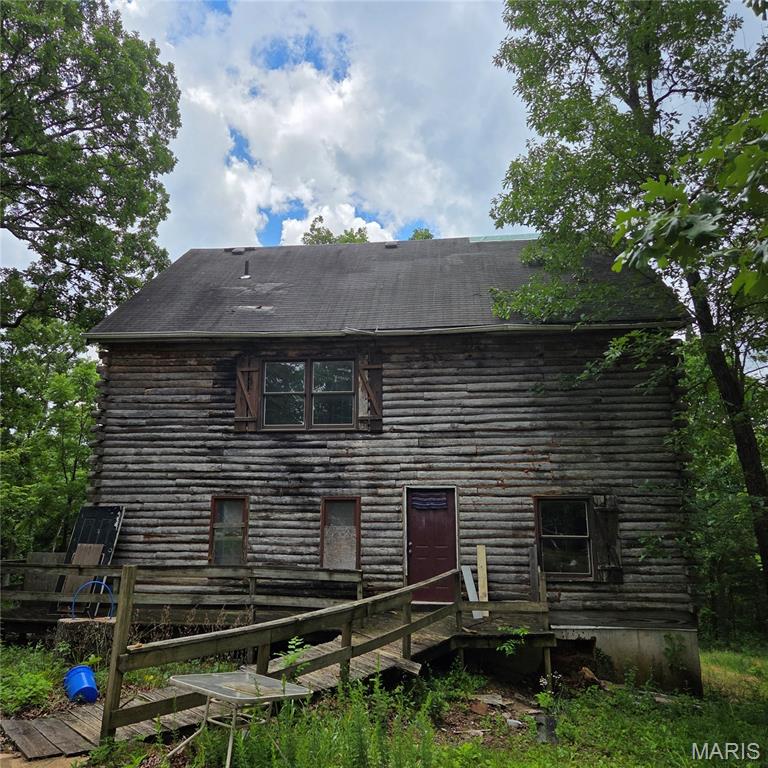 Unique log cabin style home with over 2,300 sq ft of living space, over 5.8 acres and 2 caves.  This house boasts 6 bedrooms and 2 full baths as well as a lot of space to entertain.  This home has good bones but is in need of a full rehab.