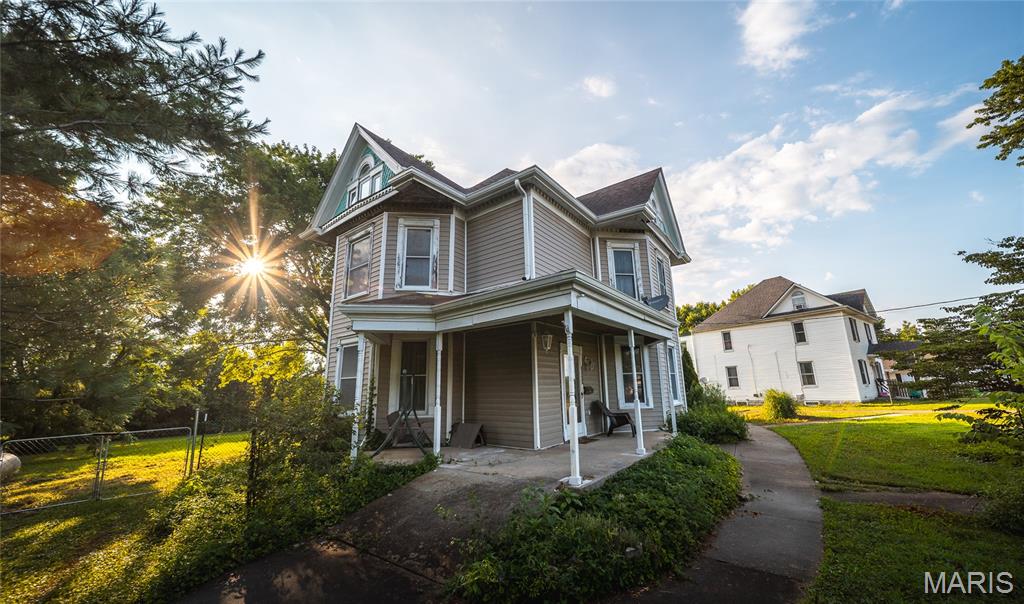 Step back in time without sacrificing modern comfort in this beautifully preserved 1880 Victorian home situated on 0.82 acres in the heart of Owensville. Rich with historic charm and timeless architectural details, this spacious 4-bedroom, 3-bath residence offers a rare opportunity to own a piece of local history while enjoying thoughtful updates for today's lifestyle. From the moment you enter, you'll be captivated by the character throughout, including original pocket and panel doors, vintage hardware, and a blend of hardwood, laminate, and carpet flooring that complements the home's classic appeal. Multiple living spaces, including a formal dining room, office, mudroom, and laundry room on the main level, provide flexibility for everyday living, entertaining, or working from home. The second and third floors offer generous bedroom space, including a private upper-level suite, while the home's unique dumbwaiter shaft—currently not in service—offers the opportunity to restore a distinctive historic feature. Enjoy peaceful mornings on the rear decks located on both the first and second floors, overlooking the fenced backyard. Recent improvements include both furnaces replaced, and a new water heater to be installed, providing added peace of mind. The stone foundation has been professionally reinforced by Foundation Recovery Systems and includes a transferable warranty, along with new interior basement stairs. A detached shed offers additional storage and has the potential to reconnect power. Historic elegance, modern updates, and endless character make this one-of-a-kind Victorian truly special. Schedule your private showing today and experience its timeless beauty for yourself!