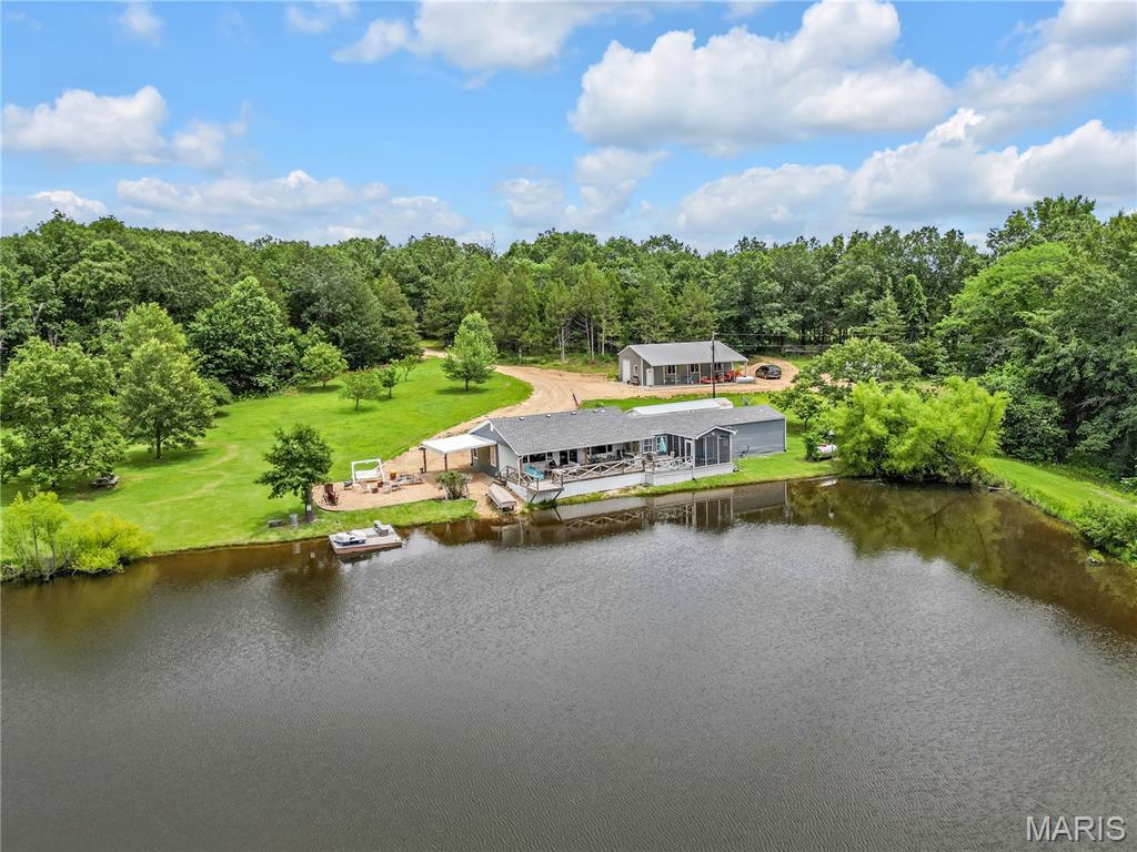 Welcome to your own 53-acre paradise! Centered around a stunning 1.8-acre private lake, this turn-key, fully furnished 3-bedroom cabin is the perfect retreat for weekend getaways, family gatherings, or full-time country living. The adorable cabin is beautifully decorated and features a wide-open kitchen, living, and dining area with breathtaking views of the lake. Step outside onto the one-of-a-kind deck that cantilevers over the water, where you can cast a fishing line right from your lawn chair while spending time with friends and family. Approximately 37 acres of the property are wooded and full of wildlife, offering endless opportunities for hunting, hiking, ATV adventures, or simply sitting back and enjoying nature's beauty. Multiple walking and ATV trails meander through the woods, complete with charming little trail signs that add to the property's storybook appeal. The property also features a fruit orchard with grapevines and a pole barn with a concrete floor for storing ATVs, boats, and equipment. Whether you're looking for an unforgettable family retreat, a peaceful full-time residence, or an investment opportunity, this property checks every box. The current owners successfully rent the property to guests when not using it, offering excellent potential as an income-producing getaway. Properties like this are incredibly rare, don't miss your chance to own this private slice of paradise!