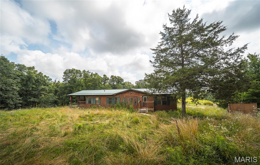 Escape to the peace and privacy you've been searching for with this secluded 3-bedroom, 2-bath manufactured home nestled on 40 breathtaking acres of mostly wooded land. Whether you're dreaming of a private homestead, a recreational retreat, or simply a place where you can unwind surrounded by nature, this property offers the space and freedom to make it your own. Step inside to an inviting open floor plan designed for comfortable everyday living and effortless entertaining. The spacious living room is anchored by a cozy wood-burning fireplace, creating the perfect gathering place on cool evenings after a day spent exploring your land. Large windows bring the beauty of the outdoors inside, while the thoughtful layout keeps everyone connected. Out back, relax on the covered deck with your morning coffee, watch the wildlife wander by, or enjoy peaceful evenings under the stars. With 40 acres to roam, you'll have endless opportunities for hiking, hunting, ATV riding, gardening, or simply enjoying the quiet beauty of your own private paradise. The impressive 30x40 shop provides ample room for vehicles, equipment, hobbies, or a workshop, making this property as practical as it is picturesque. Tucked away from the hustle and bustle yet within reach of modern conveniences, this is the perfect blend of comfort, privacy, and country living. Properties offering this much land, seclusion, and versatility are hard to find. Schedule your private showing today and experience everything this incredible property has to offer!