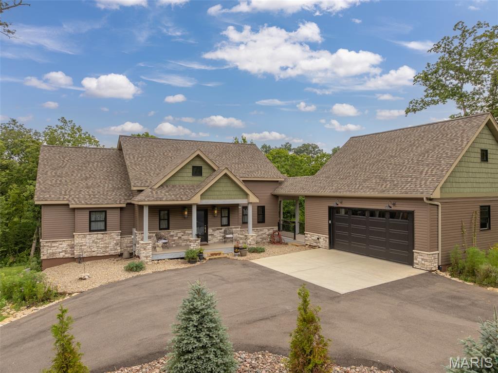 Less  than 3 years old, this expanded custom Cottage floorplan offers the ultimate in resort living. With 3 private bedrooms, each with its own bath, spacious great room with vaulted ceilings and skylights, an open floorplan and a chefs designed kitchen, there is plenty of room for entertaining as well as overnight accommodations. Custom features include a customized kitchen with center island counter, Cafe appliances, with gas cooktop, custom cabinetry (including a floor to ceiling pull out spice rack) walk in pantry, and a pass thru window to the outside screened in porch. ML engineered hardwood floors, 4 fireplaces, ( one each on the outside deck and lower patio) spacious ML great room as well as LL family room provide plenty of entertaining options. ML primary bedroom offers access to private screened porch, spacious bath with soaking tub, walk-in shower, walk in closet and laundry. Additional screen porch offers the perfect spot for morning coffee. Maintenance free decking, vinyl siding provide a minimal maintenance free lifestyle. Attached oversized 2 car garage with built in shelving, lower level patio with covered decking and included resistance swim spa. Centrally located to Charrette commons recreation complex, Tyrol and Freiden lakes. Some furniture and boat available separately