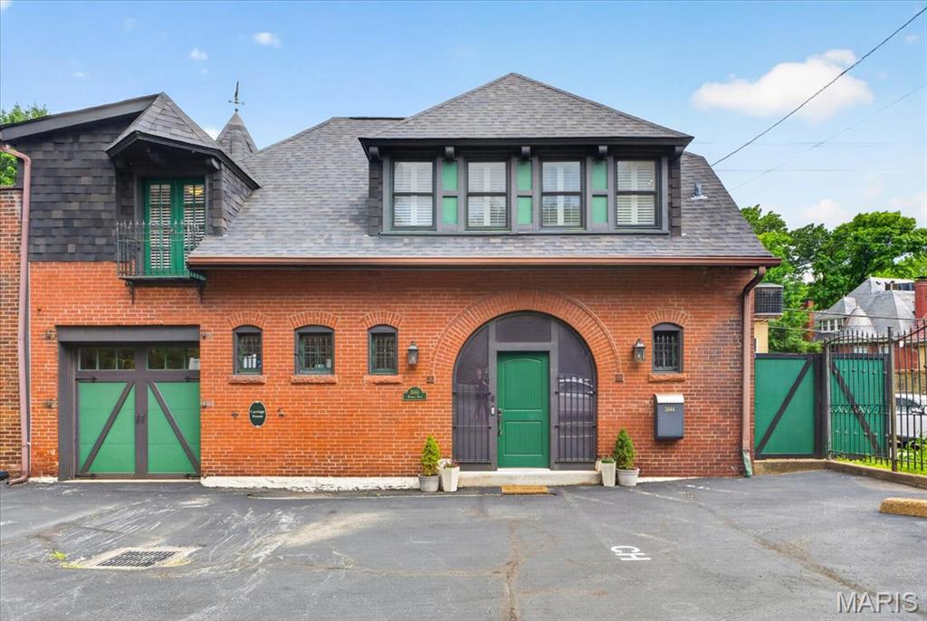 Circa 1889, this carriage house is an architectural gem totally hidden in plain sight, secluded, and private. Built by beer Baron, Wm. J. Lemp, this home has quite a history. Restored and converted into a home in the 1980s, the current owners have gracefully updated the property and lovingly maintained it.  A large entry area opens into living and dining areas and the south windows keep the entire floor light & bright.  The floors are impressive yet beautiful and made from a 200 year old barn in Pennsylvania and repurposed here as flooring. Exposed brick, high ceilings, and lovely bits of carriage house charm remain. Turning to the left, is the stairway and beneath is a room straight out of Harry Potter used as a pantry and for wine storage. What a great time out room!  Ahead is the attached 1 car garage and to your right is a large modern and beautifully updated kitchen. Perfect for preparing amazing dinners and entertaining friends. Acres of granite counters and tons of cabinet storage for the discerning cook. There is a stylish updated full bath off the kitchen. Two separate doors, one off the kitchen and one off the living area lead onto a nice composite deck running the length of the house. Private, it boasts pots for plants, seating, and a spa. Around the corner are raised planting beds for your herbs and veggies. Upstairs you find a large open family room with dramatic high ceilings along with an spacious alcove used as an office which can double as another bedroom area for overflow guests. A 2nd bedroom with porthole windows and angle bay walls with more windows has hardwood floors and is totally charming. The primary bedroom on the other side of the house is large and features built-in bedside tables and platform bed, which contain the old pulley systems for loading carriages to the 2nd floor. Through a walk-in closet is the laundry and then a dressing room and then another large tastefully updated modern full bath. Gorgeous tile and fixtures were used in both baths found in the home. Interesting, charming, private, secluded, and totally modern describe this one of a kind property. This home is part of the Adlon Condo association, so water, gas, trash, sewer are part of the low monthly assessment but the owners are responsible for the exterior maintenance. In addition to the attached 1 Car Garage, there are 2 assigned parking spots directly outside the home marked CH100. This home is perfect for someone looking for a great lock n leave, pied-a-terre in the city, or downsizing property. Start your new chapter of history for this wonderful home.