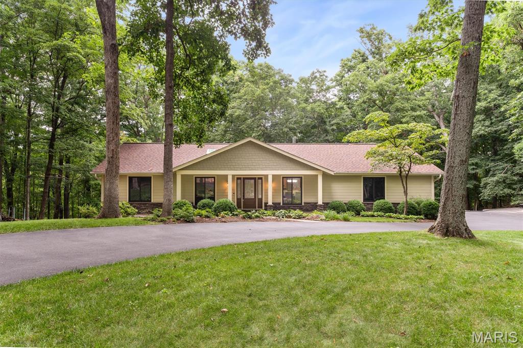 Welcome home to this beautifully updated and meticulously maintained 4-bedroom ranch, privately situated on 4.5 wooded acres in one of Wildwood's sought-after neighborhoods. A circular driveway, inviting front porch, charming landscaping, and warm wood entry door create exceptional curb appeal and a welcoming first impression. Inside, the open-concept floor plan is highlighted by a stunning great room featuring soaring vaulted ceilings, multiple skylights, beautiful flooring, and a dramatic stacked stone fireplace. Designed for both comfortable everyday living, the spacious kitchen offers abundant cabinetry, double ovens, a butler's pantry, and a convenient main-level laundry/mudroom. The main level includes three generously sized bedrooms, along with a light-filled four-season room that provides the perfect space to relax and enjoy the surrounding natural beauty throughout the year. Step outside to two expansive decks overlooking the peaceful, wooded setting - ideal for entertaining, morning coffee, or quiet evenings immersed in nature. The finished walkout lower level adds exceptional living space with a spacious family room centered around a cozy wood-burning stove, a bar area, a large fourth bedroom with a walk-in closet, a full bath, and abundant storage. Offering the perfect balance of privacy and convenience, this remarkable property is just minutes from shopping, dining, parks, and everyday amenities. Lovingly cared for and thoughtfully updated, this is a rare opportunity to own an exceptional home in one of Wildwood's most desirable settings.