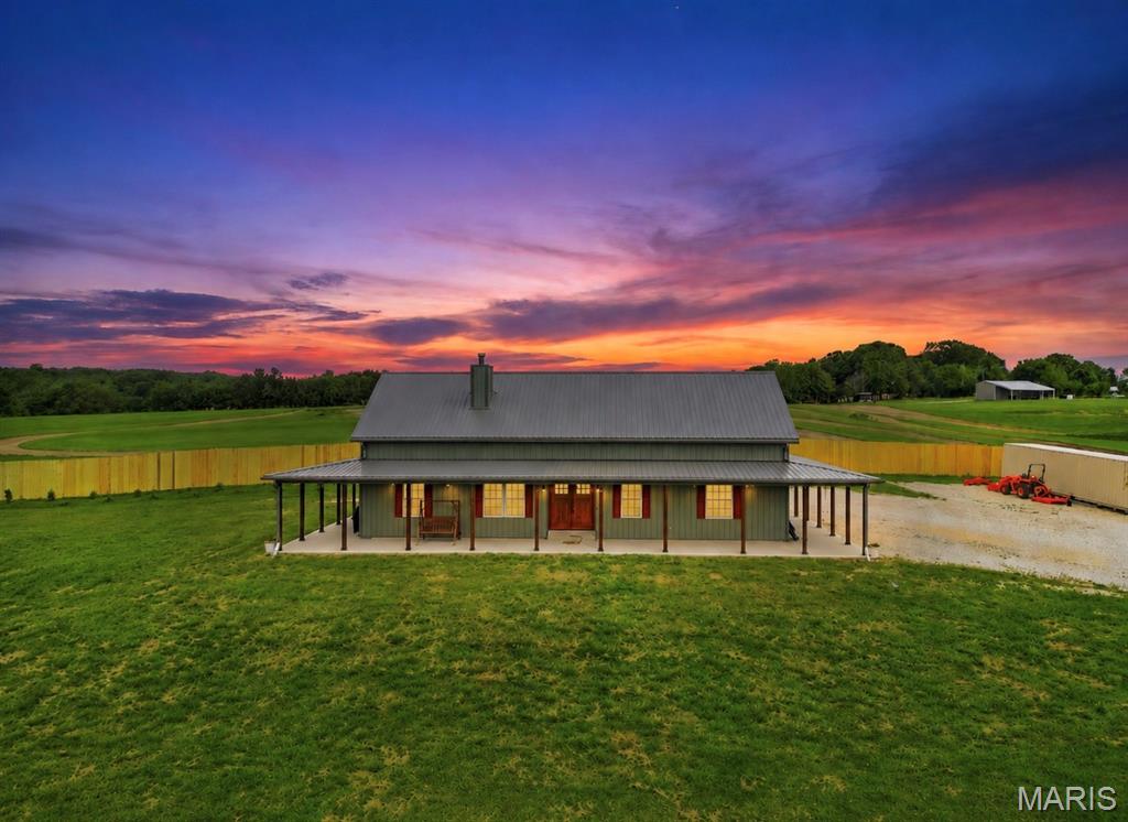Custom-built 3 bedroom, 2 bath ranch situated on 8 acres with the perfect blend of space, functionality, and convenience. This well-designed home features tall ceilings throughout, custom cabinetry, upgraded countertops, and an open layout ideal for everyday living and entertaining. Enjoy the expansive covered front porch that spans the front of the home, providing a welcoming outdoor living space with plenty of room for seating and gatherings. You will love the laundry room just off the back of the house equipped with a Doggie Wash and water bowl filler for man's best friend. Open living areas the whole family will love with stone fire place being the focal point to the room.  Kitchen has custom made Amish cabinets and large center island! Primary suite will be the perfect space to unwind after a long day with tons of space, large tub, double sink vanity, WIC, and step in shower. The full basement offers incredible potential with partial framing already completed, plumbing roughed in for a future bathroom, an egress window, and a concrete safe room located beneath the porch. Whether you’re looking for extra storage, room to expand, or additional finished living space, the basement is ready for your vision. High-speed internet is available, making it easy to work, stream, and stay connected. Conveniently located just 10 minutes from the interstate, you’ll enjoy the benefits of acreage living with quick access to shopping, dining, and commuting routes. This property offers the opportunity to enjoy wide-open space, quality craftsmanship, and room to grow both inside and out.