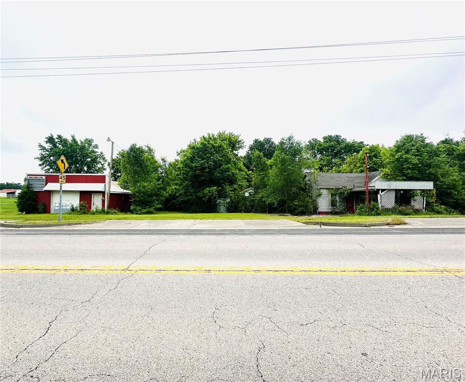 This property presents a unique opportunity for investors, builders, or buyers looking for a project with potential. Situated on a spacious lot, the property includes a large shop building with ample storage- though repairs and updates will be required, and an existing home once used as a business- currently deemed unlivable and in need of significant renovation or removal. This property is situated on a busy highway offering visibility for a potential business opportunity.  Property is being sold as-is.