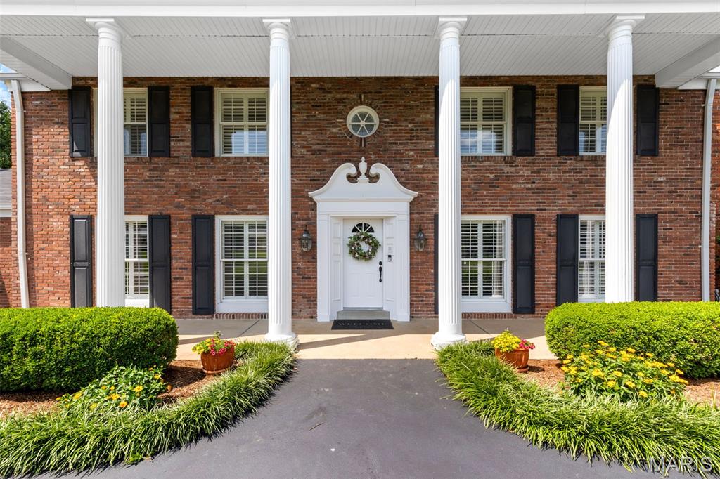 Timeless Colonial elegance meets modern comfort in this beautiful and spacious 4-bedroom, 5-bath home on a manicured 1-acre lot in a private, gated West County neighborhood. With over 3,500 sq ft, the home features stately pillars, plantation shutters, and a backyard oasis with inground pool, composite deck, and lush landscaping.  A sun-filled vaulted sunroom with full window walls offers seamless indoor-outdoor living. Inside, the kitchen features custom cabinetry, granite counters, stainless appliances, and a newer (Jan 2024) KitchenAid refrigerator. Two wood burning fireplaces, zoned HVAC, and a spacious primary suite with sitting area and updated en-suite bath add comfort and style.  Additional highlights include Pella windows, newer main furnace (2023), refinished driveway (2022), and a finished lower level with rec space and half bath. All 4 bedrooms and 3 full baths are upstairs. Neighborhood amenities include pool and tennis. Parkway West/Mason Ridge schools and unbeatable location near hospitals, shopping, and highways.