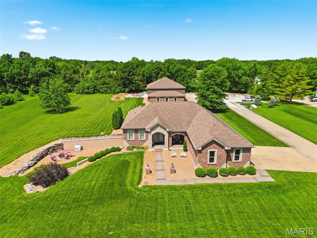 Showings begin after Open House on Sunday, May 31st, 1-3.
Custom Ranch on 3 Acres with Massive Garage!
This is a rare find! A stunning custom-built ranch home built in 2015, sitting on a level, 3-acre lot in a peaceful rural setting in beautiful St. Paul. But that's just the beginning — also included is an impressive 2,640 sq ft additional garage that takes car enthusiasm to a whole new level.
Inside this exquisite 2,458 sq ft home, 9-ft ceilings and gleaming hardwood floors set the tone throughout the main living areas. The chef's kitchen is a showpiece, featuring granite countertops, soft-close 42" cabinets, a center island, stainless steel appliances, and a large breakfast room bathed in natural light. The living room invites you to relax by the gas fireplace, and a dedicated main-floor office adds everyday convenience. The split-bedroom floorplan includes three generous bedrooms, each with its own private bath, and a main-floor laundry rounds out the thoughtful layout. Stylish espresso-brown paneled doors add a modern, designer touch throughout. The covered back patio with a ceiling fan features beautifully finished stamped concrete, as does the front porch.
Downstairs, the professionally finished walkout lower level adds another 1,500 sq ft of living space and is an entertainer's paradise — complete with a fourth bedroom, full bathroom, a pool table room, a spacious family room, party area with a wet bar, and abundant storage. Step outside to a fire pit area just off the walkout - perfect for relaxing evenings under the stars.
This home was built to last and built to breathe. Exterior 2x6 wall construction with R-19 insulation delivers exceptional energy efficiency; paired with a geothermal heating and cooling system and a fresh-air ventilation system, it ensures healthy, continuously circulated air throughout the home.  Water quality is covered from every angle — a whole-house water filter and water softener protect every tap, while a dedicated reverse osmosis system at the kitchen faucet delivers pure drinking water on demand.
And then there's the garage. The 2,640 sq ft additional garage features three bays with 14-ft doors, a built-in air compressor system, a car lift, and its own office with a half bath. The 5-1/2" poured concrete driveway,  pad, and garage floor were engineered for strength and longevity.  Whether you're a car collector, mechanic, or hobbyist, this space is truly one of a kind.
Properties combining luxury finishes, acreage, and a shop of this caliber simply don't come along often. Schedule your private showing today!