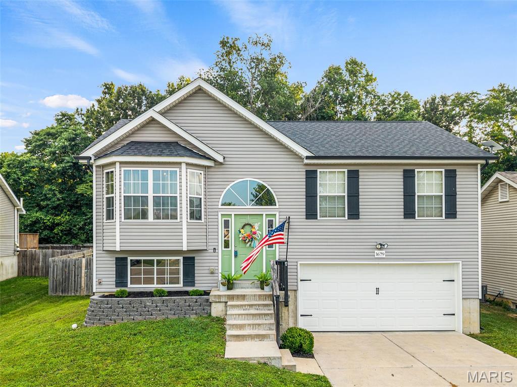 Move-In Ready in Stonewater! Welcome to 1679 Waters Edge Way in Pevely—an impeccably maintained split-foyer home offering 3 bedrooms, 2 full bathrooms, and 1,064 square feet of stylish, modern living.
Built 8 years ago, this home has been thoughtfully upgraded with a brand-new roof (2026), updated interior paint, new kitchen island, farmhouse sink, new stove/oven, painted interior doors, and updated light fixtures throughout. Every bedroom features overhead lighting and ceiling fans for added comfort.
From the moment you arrive, you’ll appreciate the home’s charming curb appeal with new front landscaping and a beautifully constructed retaining wall. Step inside and head upstairs to an inviting open-concept living room, dining area, and kitchen, where soaring vaulted ceilings, abundant natural light, and scratch-resistant engineered wood flooring create a bright and welcoming space. The updated kitchen is ideal for both everyday living and entertaining, with a center island, modern finishes, and seamless flow into the dining and living areas.
Sliding glass doors off the dining room lead to the deck overlooking the fully fenced, level backyard that backs to mature woods, providing exceptional privacy. The backyard also features raised garden beds, a parking pad with double gate access for a boat or outdoor toys, a small pool, and a storage shed that stays with the home.
The unfinished walkout lower level is ready for your personal touch, featuring a rough-in for a future full bathroom and ample space to finish into a family room, home office, additional bedroom, gym, or recreation area. The oversized two-car garage offers built-in storage, a workbench area, and a 220V outlet ready for your electric vehicle.
As an added bonus, the small pool, patio set, primary bedroom furniture AND the Whirlpool washer and dryer set are included! Located just steps from Stonewater’s private fishing lake and scenic walking trail, this home combines modern convenience with outdoor recreation. Clean, updated, and truly move-in ready—schedule your private showing today before it’s gone! PUBLIC OPEN HOUSE SAT 7/11 from 12-2PM!
