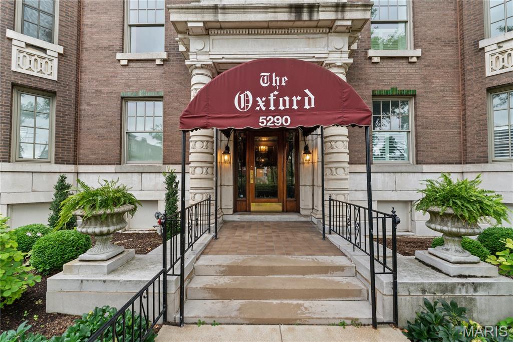 Set within The Oxford, one of the Central West End's most distinguished residential buildings, this beautifully renovated second-floor residence offers 2,578 square feet with the scale and architectural character rarely found in condo living. A welcoming gallery opens to an expansive living room anchored by a fireplace flanked by floor-to-ceiling built-ins. Tall ceilings, oak hardwood floors, and generous proportions provide an inviting atmosphere for entertaining, while a sunroom wrapped in painted brick and lined with windows extends the living space and offers a light-filled place to relax. The formal dining room, appointed with silver grass cloth wallpaper, creates a chic backdrop for dinner parties. The kitchen features custom white cabinetry, stainless steel appliances, and timeless finishes. The primary suite has been completely reimagined with a marble-clad bath featuring a walk-in shower and an adjoining dressing room reminiscent of a luxury hotel. Two additional bedrooms are served by a second full bath, while the brand-new powder room with a marble sink is ideal for guests. A dedicated office overlooking the pool and tennis courts is accented with striking white-and-gold wallpaper and can serve as a fourth bedroom. In-unit laundry room with extra-large, commercial washer and dryer completes the home. With just 18 residences, The Oxford offers a quiet, refined environment with amenities including a pool, fitness center, tennis and pickleball courts, elevator service, generous private storage, and two gated parking spaces. Moments from Forest Park and the restaurants, galleries, and shops of the Central West End, this home represents sophisticated condominium living in one of St. Louis' most desirable neighborhoods.