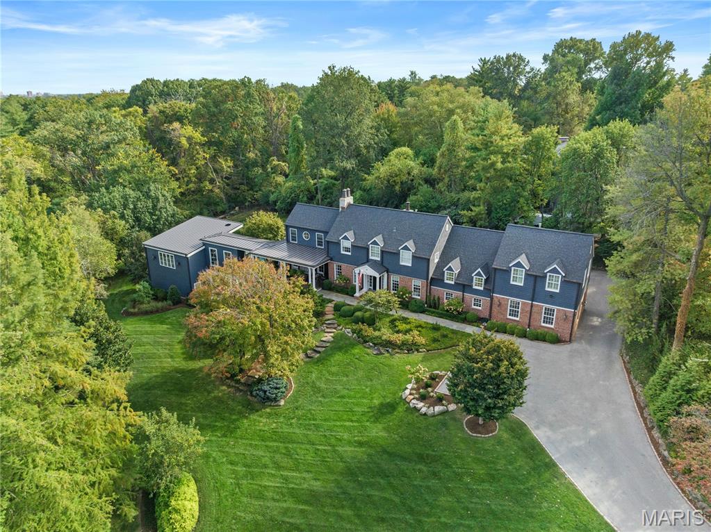 Set on 1.6 private acres along one of Ladue’s most coveted lanes, this stunning 4-bedroom, 5.5-bath, 7,373-square-foot estate, perched atop a hill, offers refined, effortless living. With magazine-worthy interiors featured on three design covers, the home has been thoughtfully renovated and meticulously maintained, blending timeless design with everyday comfort. A bluestone walkway leads to the inviting entry, where light-filled rooms, walnut floors, natural stone, and four fireplaces strike a balance between sophistication and ease. The chef’s kitchen opens seamlessly to both casual and formal dining areas and features heated floors, custom cabinetry, a butler’s pantry, and top-of-the-line SubZero and Wolf appliances. The main level also includes a generous laundry room with two sets of washers and dryers, a billiard room, and an expansive great room with a wet bar and additional dishwasher — ideal for effortless entertaining. Upstairs, a handsome study and luxurious primary suite offer a quiet retreat, complete with a fireplace, bay window, and a spa-like bath with a freestanding tub and oversized shower. Three additional bedrooms include two private en-suite retreats. Outdoor living is equally compelling. A wrap-around mahogany veranda with custom wrought-iron railings offers multiple seating areas overlooking manicured grounds, while the rear patio features a gas firepit, built-in Viking grill, and lush landscaping. At the center of the home’s California-inspired outdoor space is a resort-style saltwater pool, framed by limestone and complemented by a second Viking grill and outdoor dining area. The two-story pool house — seamlessly connected to the main home — includes a living room, custom kitchen, full bath, custom infrared sauna, and flexible recreation space, making it ideal for year-round entertaining. A rare blend of beauty, comfort, and setting, this home captures Ladue living at its finest.
