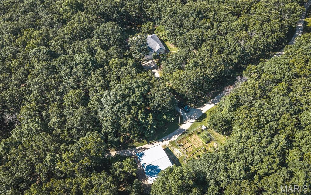 Nestled in the heart of the Ozarks with one mile bordered by the scenic Mark Twain National Forest, this exceptional 166 (+/-) acre property offers the perfect blend of comfort, privacy, and outdoor recreation. The land is fully fenced and thoughtfully maintained. Featuring four established food plots, a maintained firebreak system, ATV trails, and four ponds! The large pond is an acre, stocked, and has a one room cabin that overlooks it. The custom built home features 2-3 bedrooms and 2 full bathrooms. The kitchen boasts beautiful custom maple cabinets and stainless steel appliances. Energy efficient 6 ft tall windows opening into the sunroom offer tons of natural light and views of the abundant wildlife and stunning views. This home also has a large multilevel back deck with a hot tub making it perfect for entertaining or just enjoying nature. The garden is fenced with 6 ft chain link fence and has established blueberry and asparagus beds. Two outbuildings that are ideal for a workshop and storing your equipment. Newer roof, siding, HVAC, 16 KW emergency propane generator, FEMA design storm room, plus so much more! All this conveniently located less than 5 miles from I-44 with easy access to Fort Leonard Wood and only 3.5 miles from a blue ribbon trout stream. Big and Little Piney river are close by along with lots of other floating and fishing parks. This remarkable property is truly one you have to see to believe! Call to schedule a showing today.