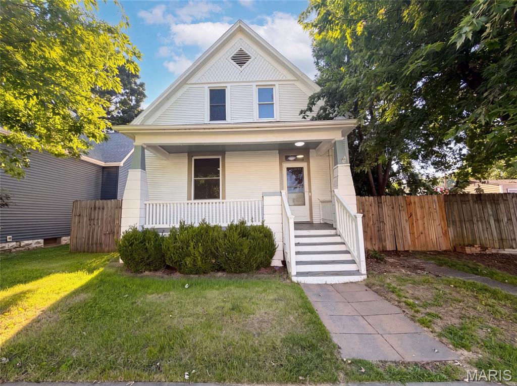 415 N 4th St is a 2-story Saint Charles home with a covered front porch. The kitchen features white cabinetry, a tile backsplash, and stainless steel appliances with wood flooring underfoot. A main living area with a ceiling fan connects to an adjoining dining space, both finished with wood floors. Bedrooms with wood flooring offer flexible use, served by full bathrooms that include a tiled walk-in shower and a tub. A lower level provides laundry space and additional storage. Outside, a fully fenced backyard and a storage shed extend the usable space. Clean interior finishes complete this well-maintained residence throughout.. Included 100-Day Home Warranty with buyer activation