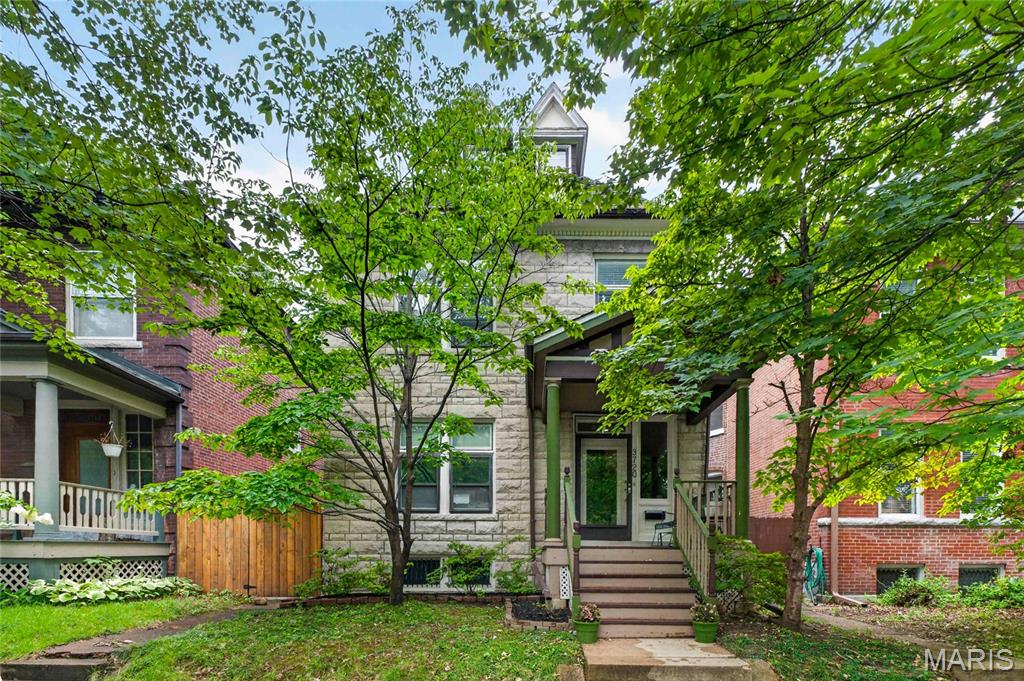 Welcome home to this charming 2.5-story historic gem where timeless character meets everyday functionality! From the moment you arrive , you'll be welcomed by the inviting covered front porch and a stunning original wood staircase accented by beautiful stained-glass windows. Rich hardwood floors flow throughout the main level, creating warmth and elegance at every turn. The cozy living room features a fireplace and oversized windows that fill the space with natural light. Just beyond, the formal dining room showcases a beautiful accent ceiling, a decorative fireplace, and plenty of room for gathering with family and friends. The kitchen offers a unique city-inspired feel with exposed brick accents, butler pantry  and convenient access to the backyard patio. A main-level half bath adds extra convenience for guests. On the upper levels, you'll find five generously sized bedrooms, each with its own unique character. One bedroom serves as a spacious walk-in closet, another features charming architectural details and beautiful windows, while another is highlighted by exposed brick walls and private access to a quaint balcony. A full bathroom completes the upper level. Outside, enjoy the level, fenced backyard with a concrete patio—perfect for entertaining, relaxing, or letting pets play. The detached two-car garage provides additional storage and off-street parking. Ideally located within walking distance to local shops, restaurants, and everyday conveniences, this home offers the perfect blend of historic charm, modern functionality, and an unbeatable location. Don't miss your opportunity to own this one-of-a-kind property!