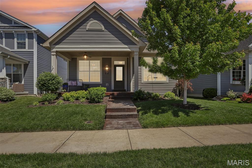 Built in 2018, this ranch-style home is part of Payne Family Homes’ Urban Collection, a niche community designed for low-maintenance living with the benefits of newer construction and a connected neighborhood setting. Located near Wildwood Town Center, the home offers access to local restaurants, shops, parks, and nearby community amenities while maintaining minimal road noise and a quieter residential setting. Nearby outdoor spaces include walking trails, Bluff View Park, and Wildwood’s future Village Green all-inclusive playground currently under development.
The exterior offers strong curb appeal with a covered front porch, maintained landscaping, and rear patio space. Inside, the open-concept layout features luxury vinyl plank flooring, recessed lighting, a gas fireplace, and large windows providing natural light throughout the main living areas. Kitchen includes quartz countertops, oversized center island with seating, gray shaker style cabinetry, quartz backsplash, stainless steel appliances, some open shelves and pantry storage.
Main-floor primary suite includes walk-in closet, double vanity, and private bath. Two additional main-floor bedrooms, full hall bath, and main-floor laundry room provide functional single-level living along with two charming receiving nooks for backpacks, coats or anything else you carry in from your day.  Finished lower level adds additional recreation space, kitchenette area , full bathroom, and flexible space for media, office, fitness, or hobbies.
Located approximately 1.2 miles from B&B Theatres Wildwood, 1.7 miles from Community Park, and near shopping, dining, and commuter routes. Includes 3D walkthrough, floor plan, and video tour.