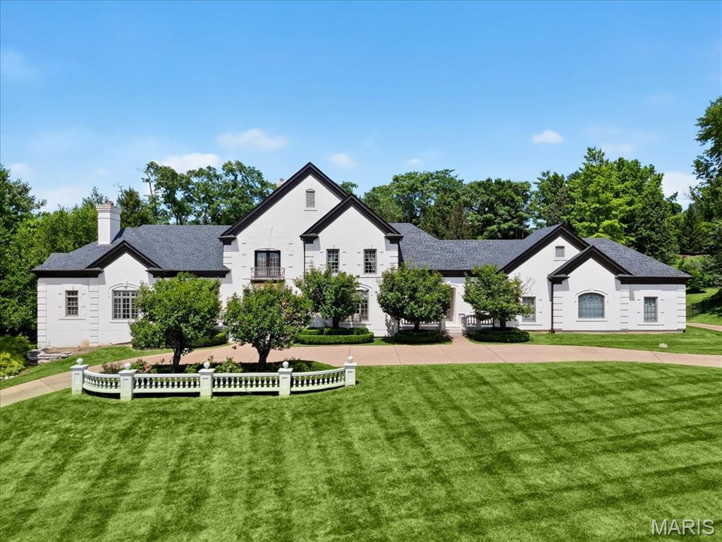 Poised for transformation, this Town & Country estate rests on nearly 2 beautifully landscaped acres in an exclusive gated enclave. Surrounded by trees, the lot provides unparalleled privacy, while the home’s generous square footage, resort-style amenities, and thoughtfully designed layout, provides a perfect personalization opportunity. Designed for entertaining, the gracious foyer invites you into the expansive living room and dining room with floor-to-ceiling windows overlooking the stunning backyard—complete with a pool with waterfalls, tennis court, and lush landscaping for your personal oasis. The spacious eat-in kitchen offers abundant cabinetry, counter space, and a breakfast room with a built-in banquette. A cozy den is ideal for movie nights, while the billiards room provides a versatile space for games, an office, or library. The main-floor primary suite, with a gas fireplace offers dual walk-in closets, soaking tub, separate shower, and dual vanities. Upstairs are two bedrooms with a shared bath, one en-suite, and a flexible fourth bedroom or creative studio. The walk-out lower level checks all the boxes with a wine cellar, theater room, guest bedroom, full bath and kitchen. Additional highlights include a spacious first-floor laundry and mudroom, a secondary service entrance, and an oversized four-car garage. With its timeless setting and impressive grounds, this property provides the canvas for a new homeowner to create their own custom masterpiece.
