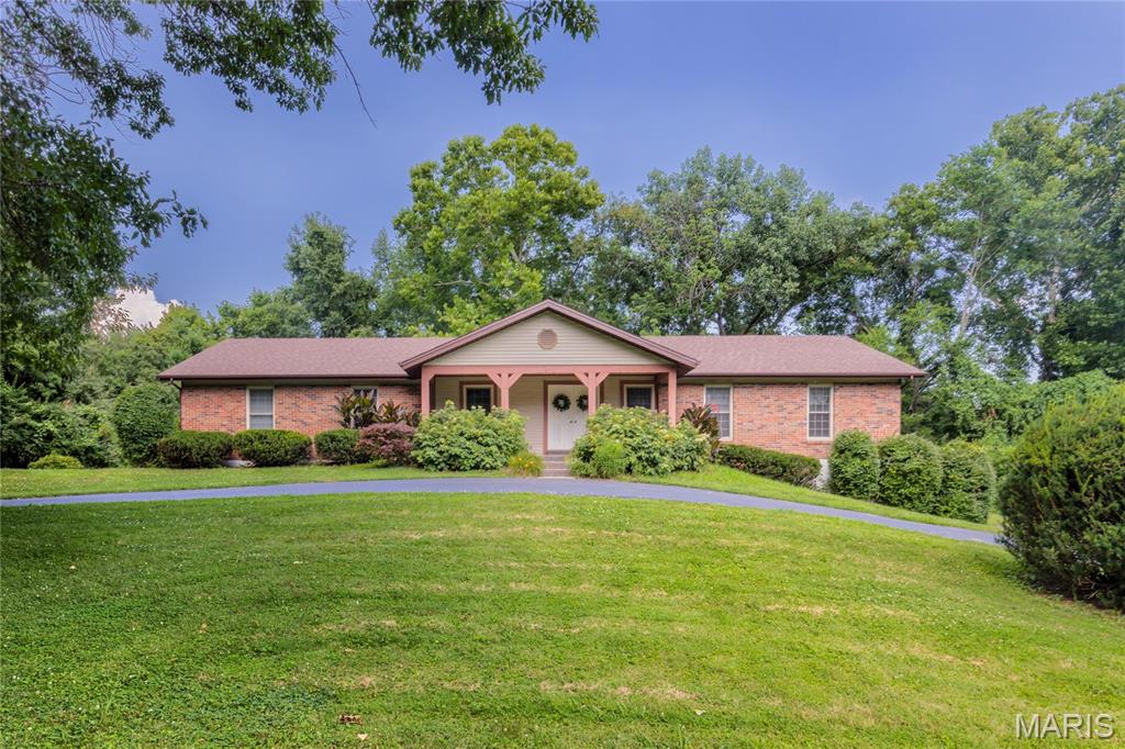 A home owned by the same family for nearly 40 years says a lot. It says the floor plan worked, the setting was worth staying for, and the home was cared for every step of the way. Now, this lovingly maintained ranch is ready for its next chapter. Set on a gorgeous 3-acre lot with a circle drive, charming front porch, and stately double front doors, this 4-bedroom ranch offers the kind of space that's getting harder to find. Step inside to a welcoming entry flanked by formal living and dining rooms before the home opens into an inviting family room anchored by a cozy fireplace. Just beyond, the beautifully renovated kitchen features granite countertops, tile backsplash, stainless steel appliances, double ovens, and an open layout that keeps everyone connected—whether you're hosting the holidays or simply enjoying a Tuesday night at home. Stunning custom hardwood floors run throughout the main living areas, while three secondary bedrooms share a well-appointed hall bath and the primary suite enjoys the privacy of its own bathroom. Out back, the composite deck is made for morning coffee, evening sunsets, and everything in between. Downstairs, the unfinished lower level is a true blank canvas, ready to become whatever your next chapter calls for. A tuck-under 3-car garage, 5-year-old roof, and decades of thoughtful care complete a home that's been updated where it counts and lovingly maintained throughout.