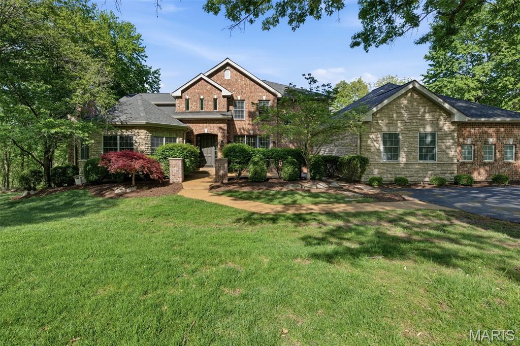 Set on nearly 3 private acres along scenic Shepard Road, this custom-built Wildwood estate offers an exceptional blend of scale, craftsmanship, and extensively updated luxury living. With over 5,400 square feet above grade and an additional 1,500+ square feet of finished lower-level space, this home has been thoughtfully refreshed to meet today’s expectations. A grand two-story foyer introduces expansive living spaces filled with natural light, rich millwork, and a layout designed for both everyday comfort and entertaining. The heart of the home is the completely reimagined kitchen (2021), designed by McCoy Design Studio and featuring custom Alspaugh cabinetry, quartz countertops and backsplash, and a large island with seating for five. High-end appliances include double ovens, double dishwashers, an induction cooktop, and a dedicated ice machine—creating a true chef’s kitchen. The main-floor primary suite serves as a private retreat, highlighted by a stunning, fully renovated bath (Karr Bick, 2021) with a steam shower, freestanding soaking tub, Mouser cabinetry, quartz surfaces, and solid brass fixtures. A custom-designed primary closet (New Space, 2022) completes the suite. Upstairs, four additional bedrooms are complemented by two fully remodeled bathrooms, both designed with elevated finishes including marble surfaces, custom cabinetry, designer lighting, and a walk-in shower in the guest ensuite. The finished lower level adds exceptional versatility with a large recreation area, additional bedroom, full bath, and ample storage. Recent updates extend throughout the home, including new hardwood flooring in the kitchen, new carpet throughout, fresh interior paint (April 2026), custom window treatments, updated lighting, and new ceiling fans. Major improvements include a new asphalt driveway (2024), updated exterior lighting (2025), EV charger, and new water softener and humidifier (2022). Outside, the nearly 3-acre setting offers privacy, mature trees, and a serene backdrop—enhanced by recent tree trimming and meticulous upkeep. This is a rare opportunity to own a beautifully updated, move-in-ready estate in one of Wildwood’s most desirable settings.