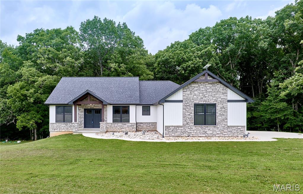 Rare 5.6-acre property offering the perfect blend of open space, wooded privacy, and a beautifully designed ranch home. This 1,704 sq. ft. home features 3 bedrooms, 2 full baths, 1 half bath, and 9' ceilings throughout. The open floor plan includes a kitchen with custom cabinetry, granite countertops, center island, and a large walk-in pantry. The split-bedroom layout offers privacy, with a spacious primary suite featuring a window seat, large walk-in closet, and ensuite bath with dual adult-height vanity, standalone tub, and walk-in shower. Two additional spacious bedrooms and a main-floor laundry room with cabinetry complete the main level. The unfinished walkout basement includes a bathroom rough-in and provides plenty of room for future expansion. Garage is equipped with 220v for EV charging station. Enjoy the outdoors from the covered front porch or covered back deck overlooking the property. A fenced backyard area, fire pit, and wooded acreage with a hiking trail create endless opportunities to enjoy nature right at home. Frequent wildlife sightings add to the peaceful, country setting. Acreage of this size and quality is hard to find, making this property a must-see.