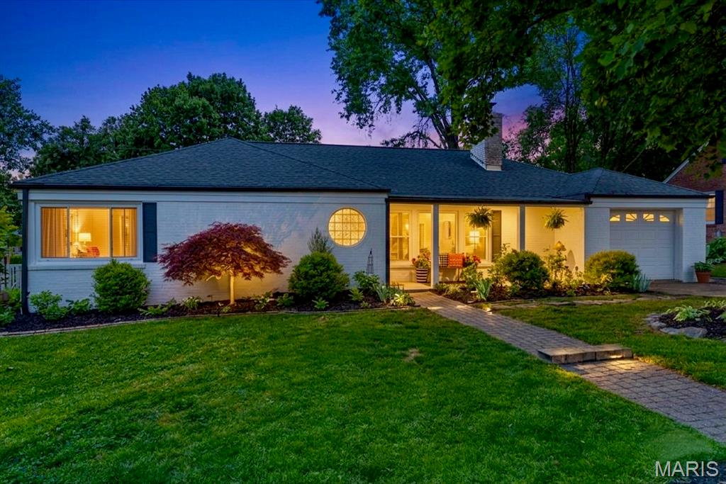 Enjoy both immediate curb appeal and the practical luxury of one-floor living in this charming, 3-bedroom mid-century modern, brick residence, tucked away in the serene Cheshire subdivision of Webster Groves. The exterior has been freshly painted in Greek Villa White. The grounds are beautifully landscaped with well-established trees and shrubs—all of which can be enjoyed from the covered front porch or the inviting rear patio. Inside, the home offers 2,117 square feet of beautifully refreshed living space finished in a soft cream tone. This crisp, new color palette perfectly complements the hardwood floors, creating a masterful blend of vintage soul and contemporary updates. Whether you are seeking a sophisticated retreat or a delightful entertaining space, the front living room delivers, anchored by a gas fireplace and framed by large windows. A signature circular window at the entrance provides a stylish architectural statement that can be appreciated from both inside and out. The heart of the home is perhaps the updated kitchen, boasting custom cabinetry, a full suite of stainless steel appliances—including a double oven and built-in microwave—and new solid surface WilsonArt Carrara Royale countertops. Enjoy morning coffee in the cozy breakfast room or host formal gatherings in the adjacent dining room. For added convenience, a well-appointed laundry room, just off the garage, provides an abundance of stylish storage.
Beyond the kitchen, a large den with built-in shelving and a wood burning fireplace awaits you. Desiring a little fresh air? Step through the den into the enclosed, screened sunroom. Beyond the sunroom a rear patio offers a secluded outdoor space for your enjoyment (new privacy fence installed late 2025). With modern comforts like central air, tilt-in windows, recessed lighting, and an in-ground sprinkler system, this move-in-ready ranch balances classic architectural detail with modern convenience. Transferrable Home Warranty provides peace of mind to the new owner. The window of opportunity is open now—are you ready for your next act?