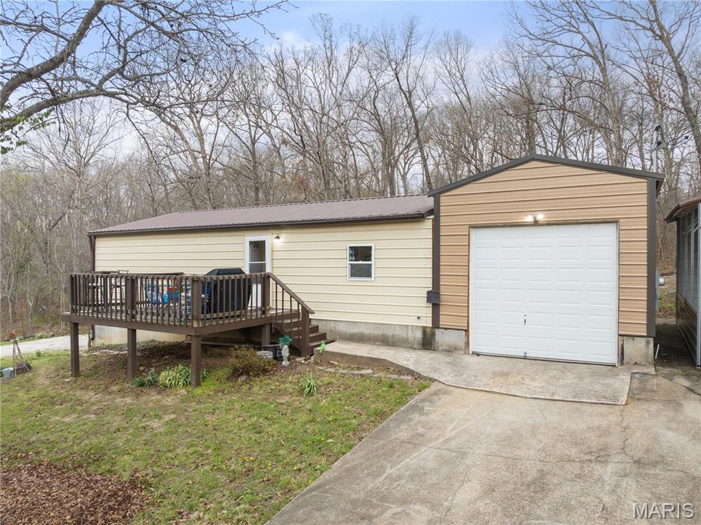 Welcome to the perfect blend of modern living and industrial utility. Built in 2022, this pristine 2-bed, 1.5-bathroom "Shouse" (Shop-House) is situated on nearly an acre of land, offering a rare sanctuary where privacy meets ultimate convenience. Located just moments from premier shopping, dining, & entertainment, this property provides a secluded feel without sacrificing accessibility. The residence is designed for durability & low maintenance, featuring high-quality metal siding, metal roof, & an inviting open deck surrounded by mature trees. Inside, the space is fresh and modern, but the true highlight lies in the expansive shop and garage facilities. A car enthusiast or mechanic’s dream, the property includes a 2-car attached garage, a 1-car detached garage, a carport, and an RV pad with full hookups. NO HOA restrictions &nearly an acre to roam, the home offers incredible expansion capabilities for those looking to grow. Whether you need a professional-grade workspace, secure storage for your lake toys, or a stylish, minimalist residence, this property delivers. Move-in ready & available now—come experience this unique lifestyle!